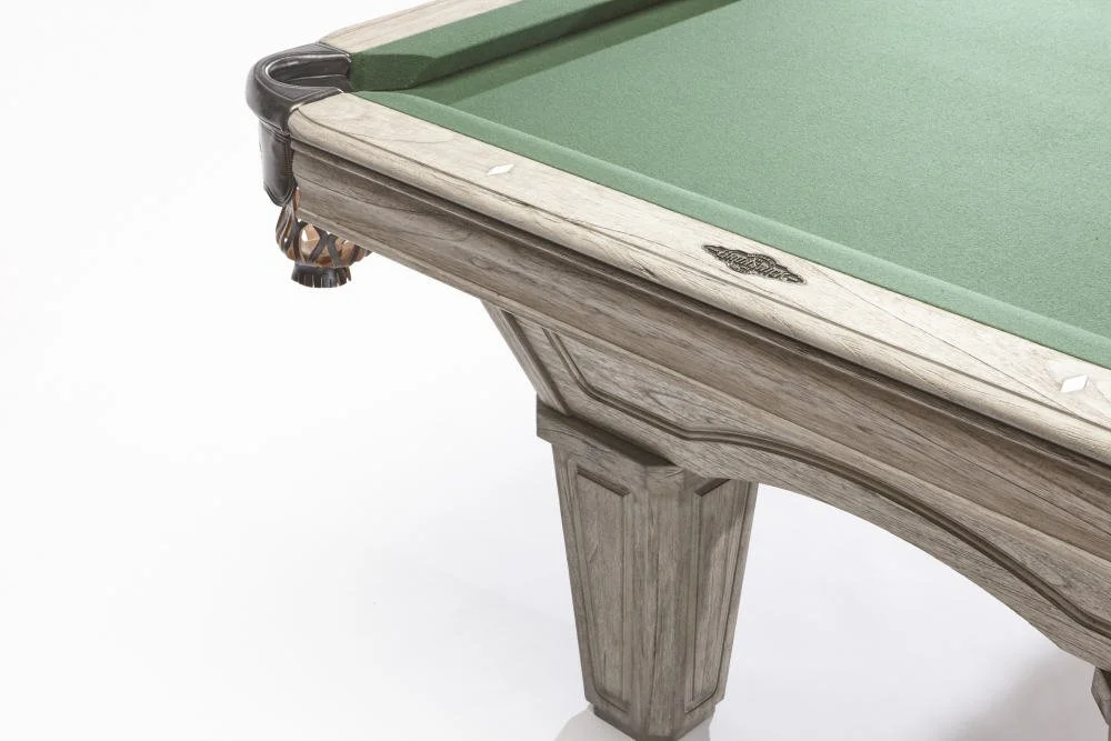 Close-up of a pool table corner with a green felt surface and wooden frame.