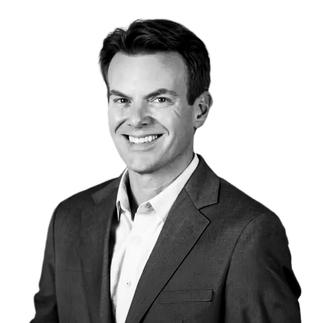 Black and white portrait of a smiling man in a suit and collared shirt.