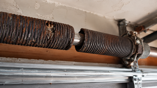 sunbaked garage door with snapped coil spring visible