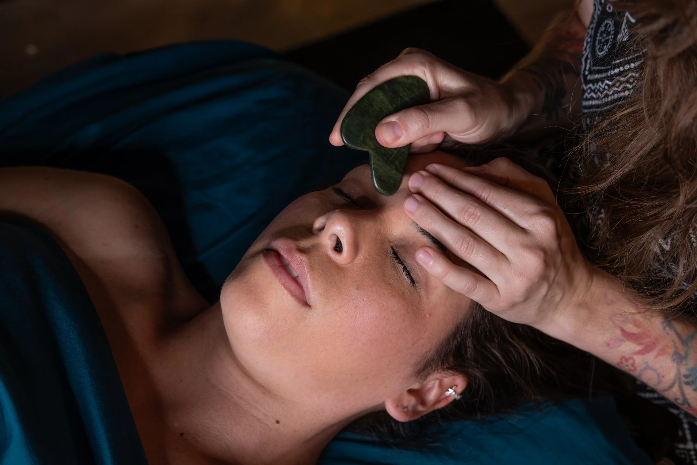 Person receiving Buccal Facelift Massage with Gua Sha for tension relief and healthier, younger looking appearance