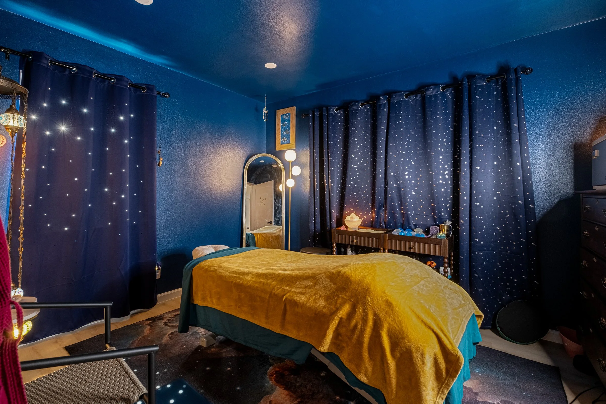 Relaxing massage therapy room with dark blues and golden accents with stars