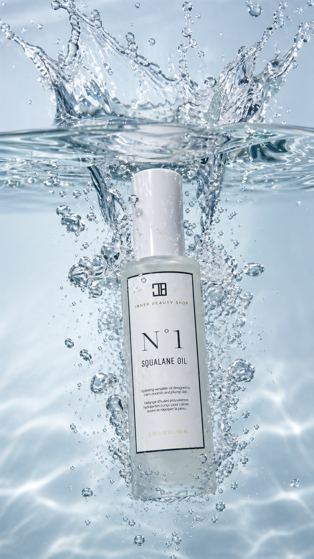 A bottle of Inner Beauty Shop N°1 Squalane Oil submerged in water with splashes and bubbles surrounding it.