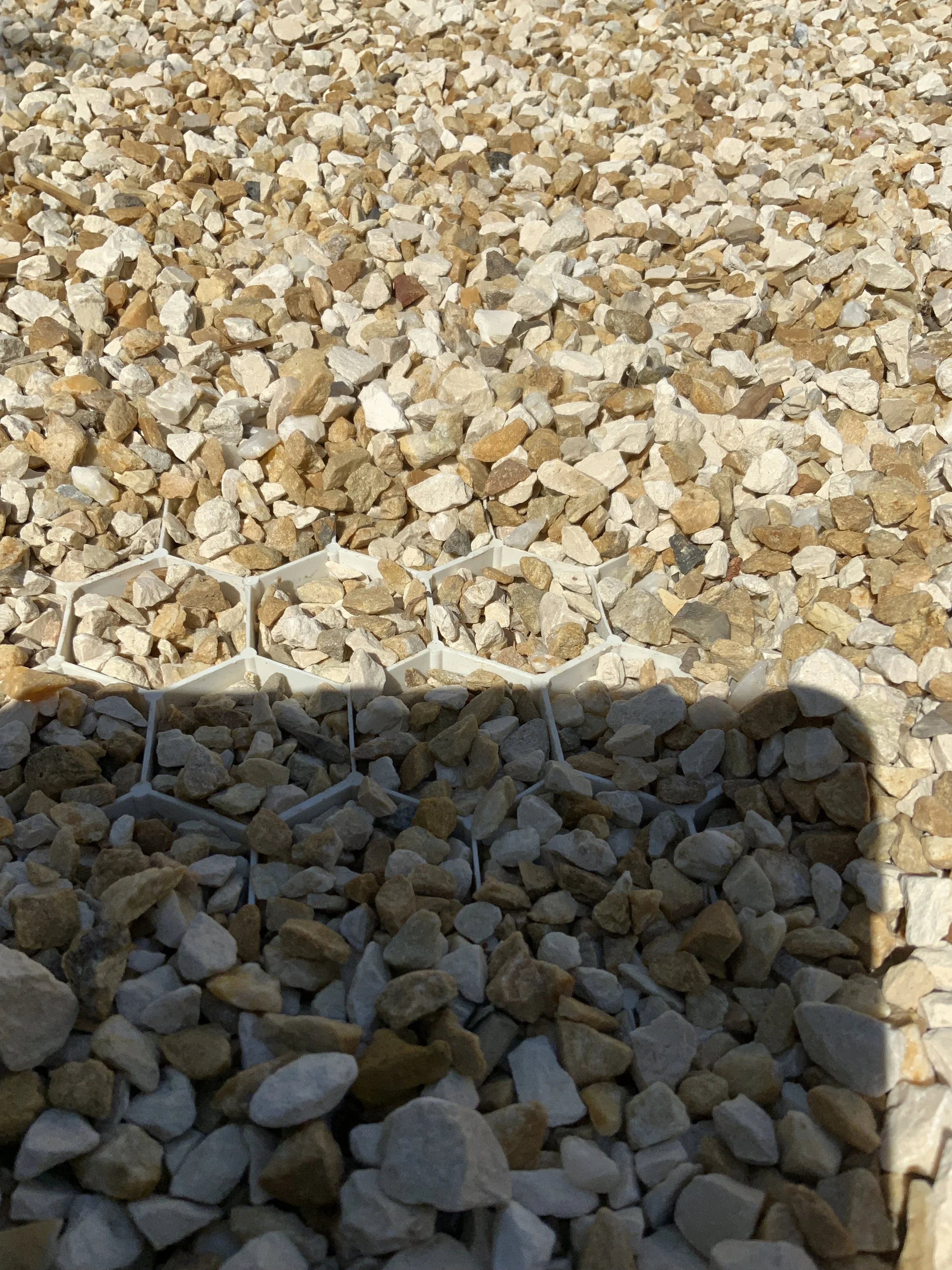 Gros plan de petits cailloux de couleur beige, blanc et gris, disposés dans des alvéoles