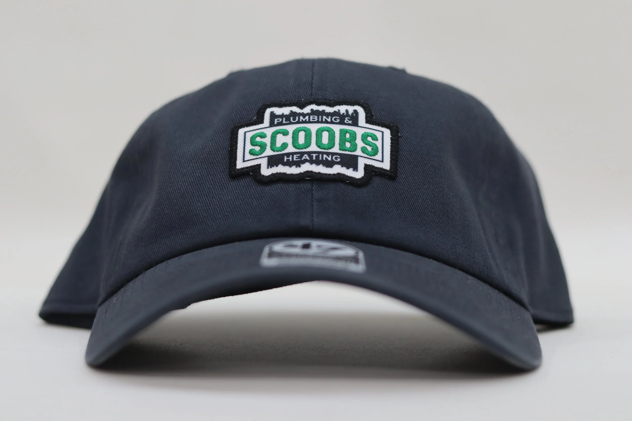 Scoobs Plumbing logo patch on a dad hat