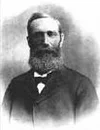 Black and white portrait of a man with a beard and mustache, wearing a suit and tie.