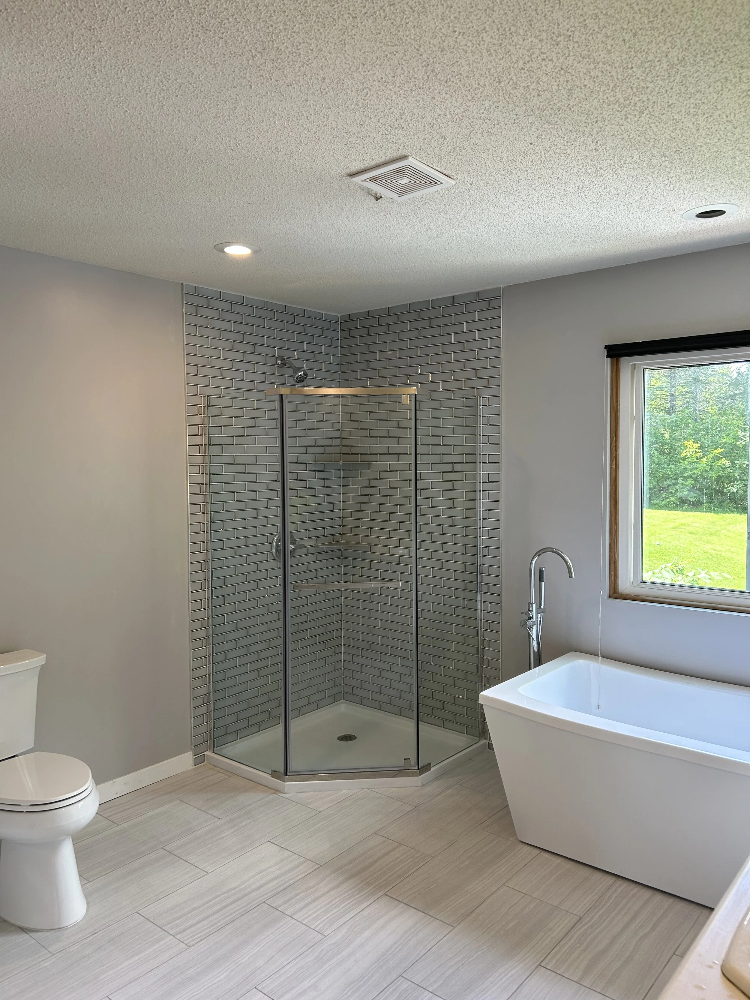 Elegant bathroom remodel featuring a custom tile shower and a new standalone tub. Quality remodeling and construction services by a Salt Lake City and Park City company, specializing in bathroom renovations.