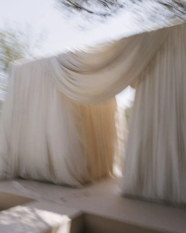 We&rsquo;re seeing draping move beyond styling detail and become the focal point of the space itself.

Layered fabric installations, gathered backdrops, and softly structured tablescapes are bringing a more atmospheric, architectural feeling to weddi