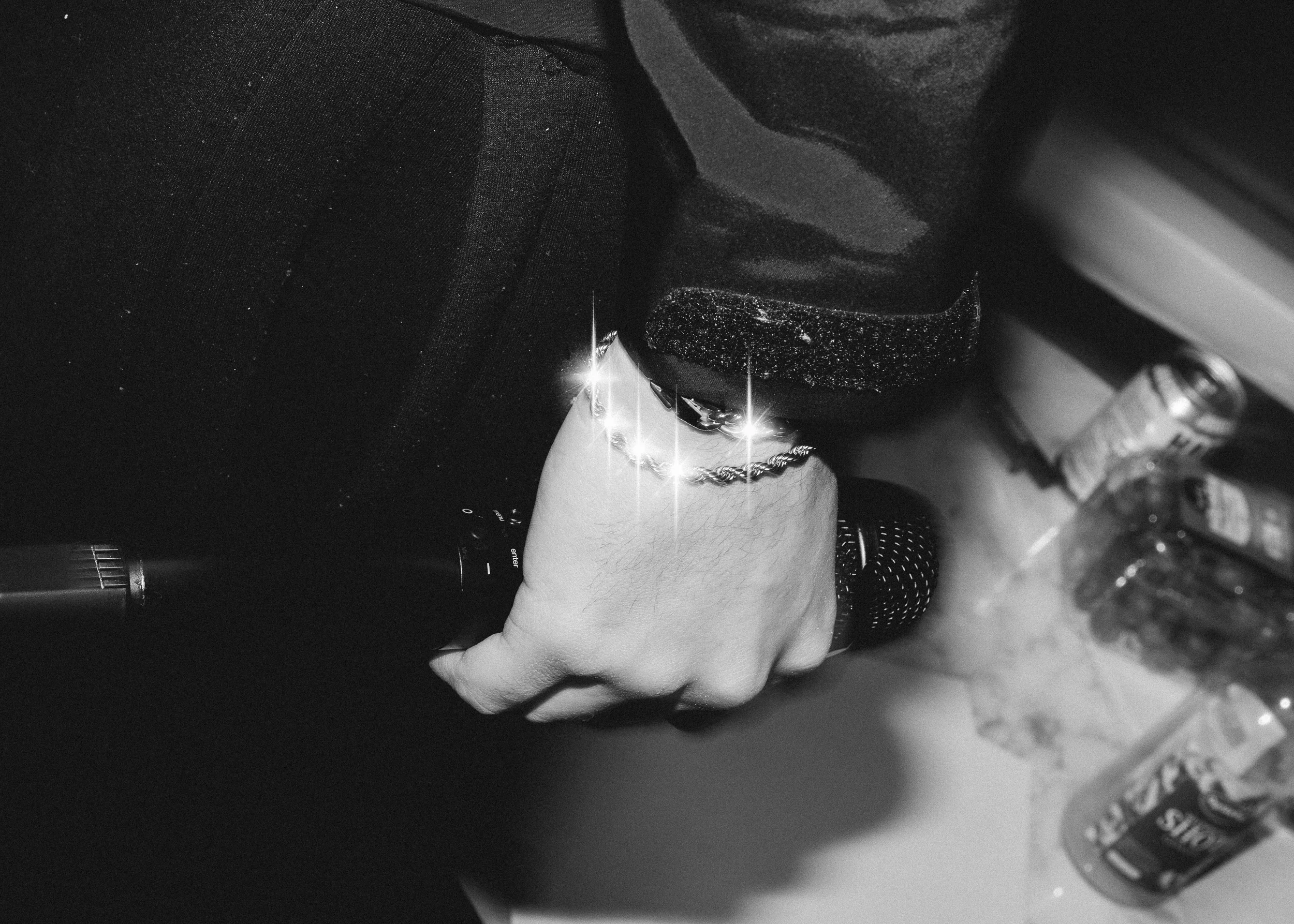 yksityiskohtakuva artisti pitää mikkiä kädessä