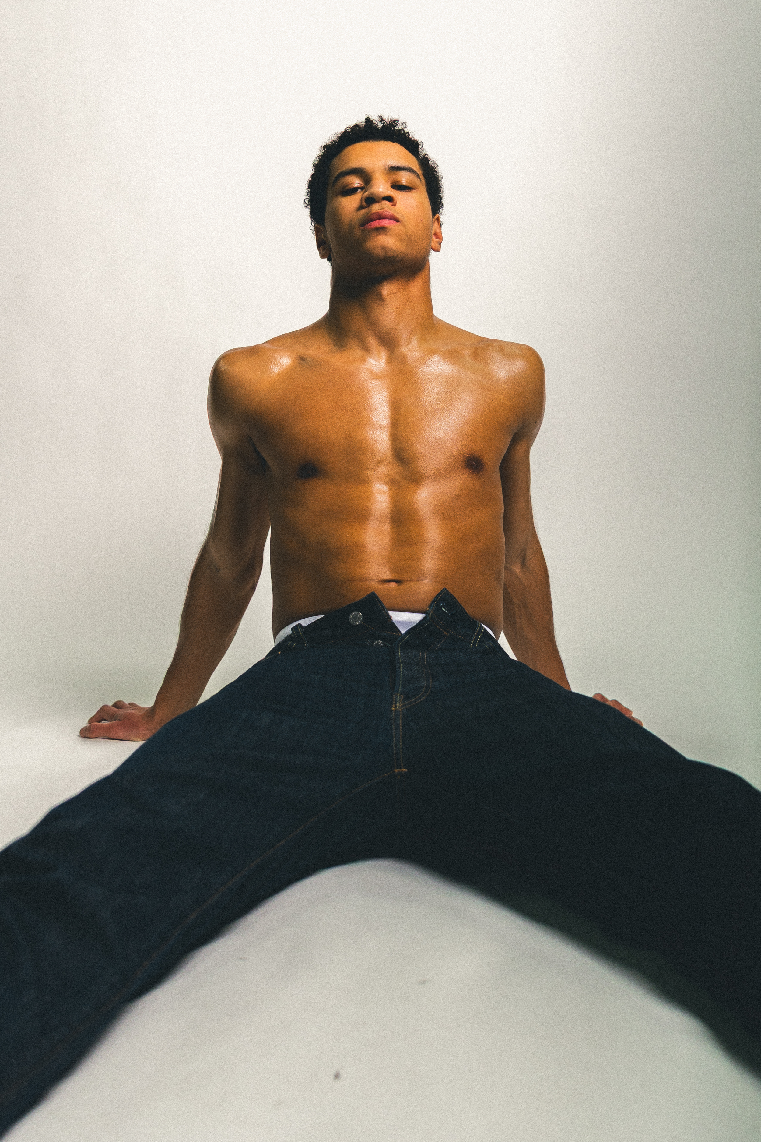 henkilökuva mies istuu ilman paitaa lattialla