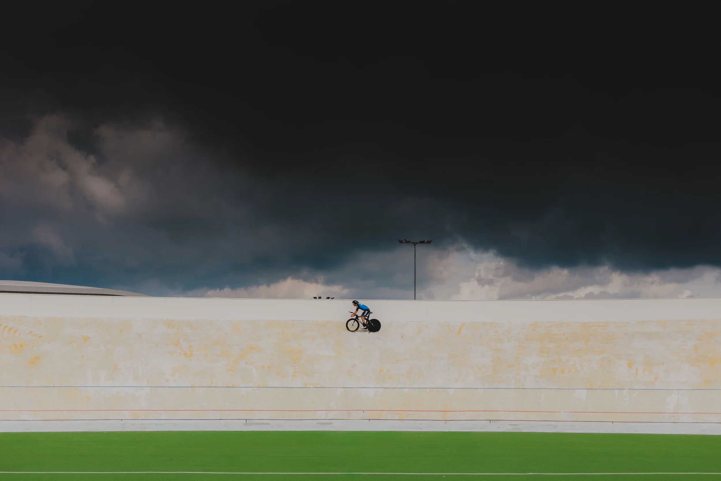 urheilukuva pyöräilijä polkee myrskyn noustessa