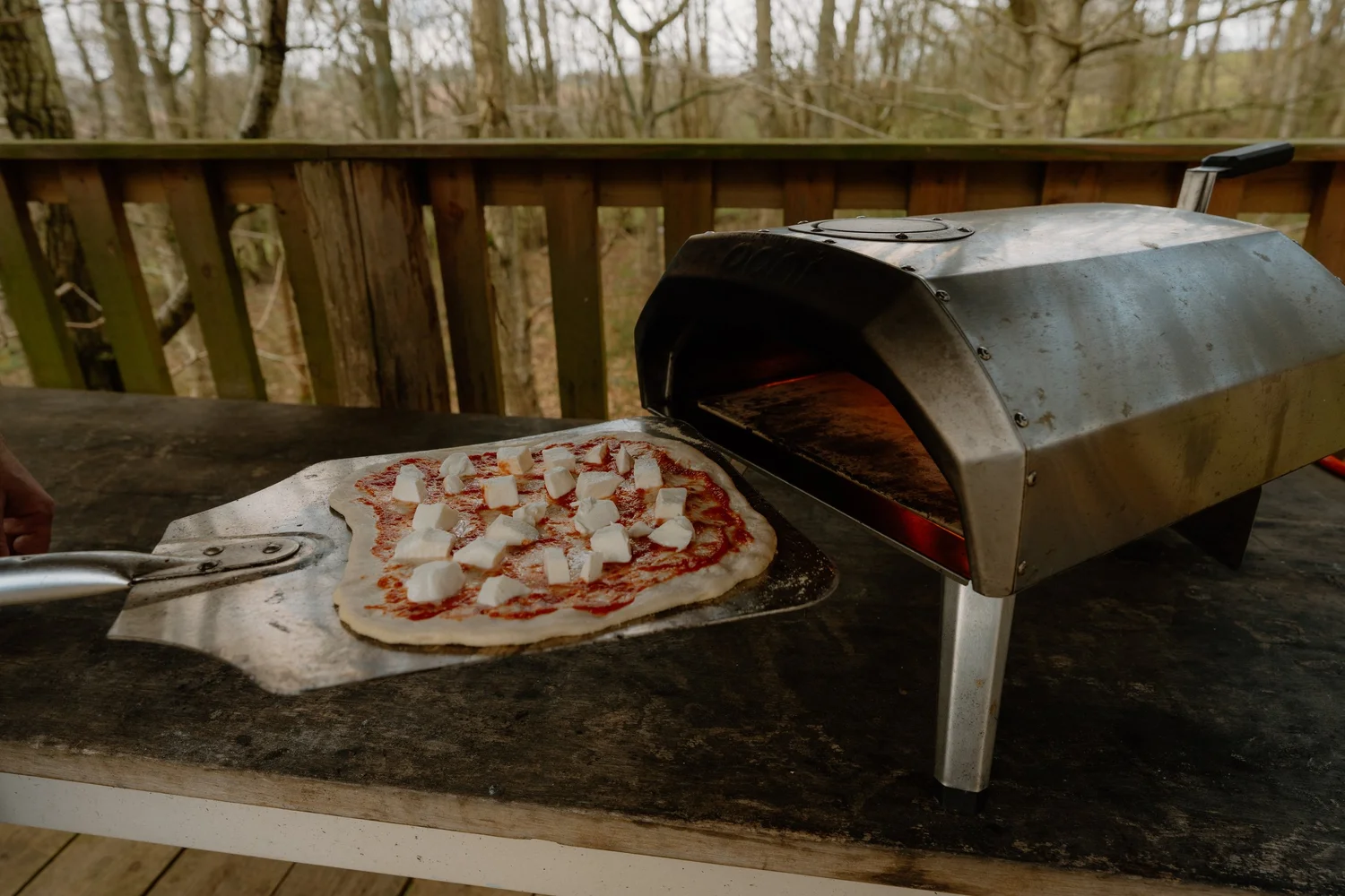 Fresh pizza being prepared in the outdoor pizza oven at Journeyman Treehouse