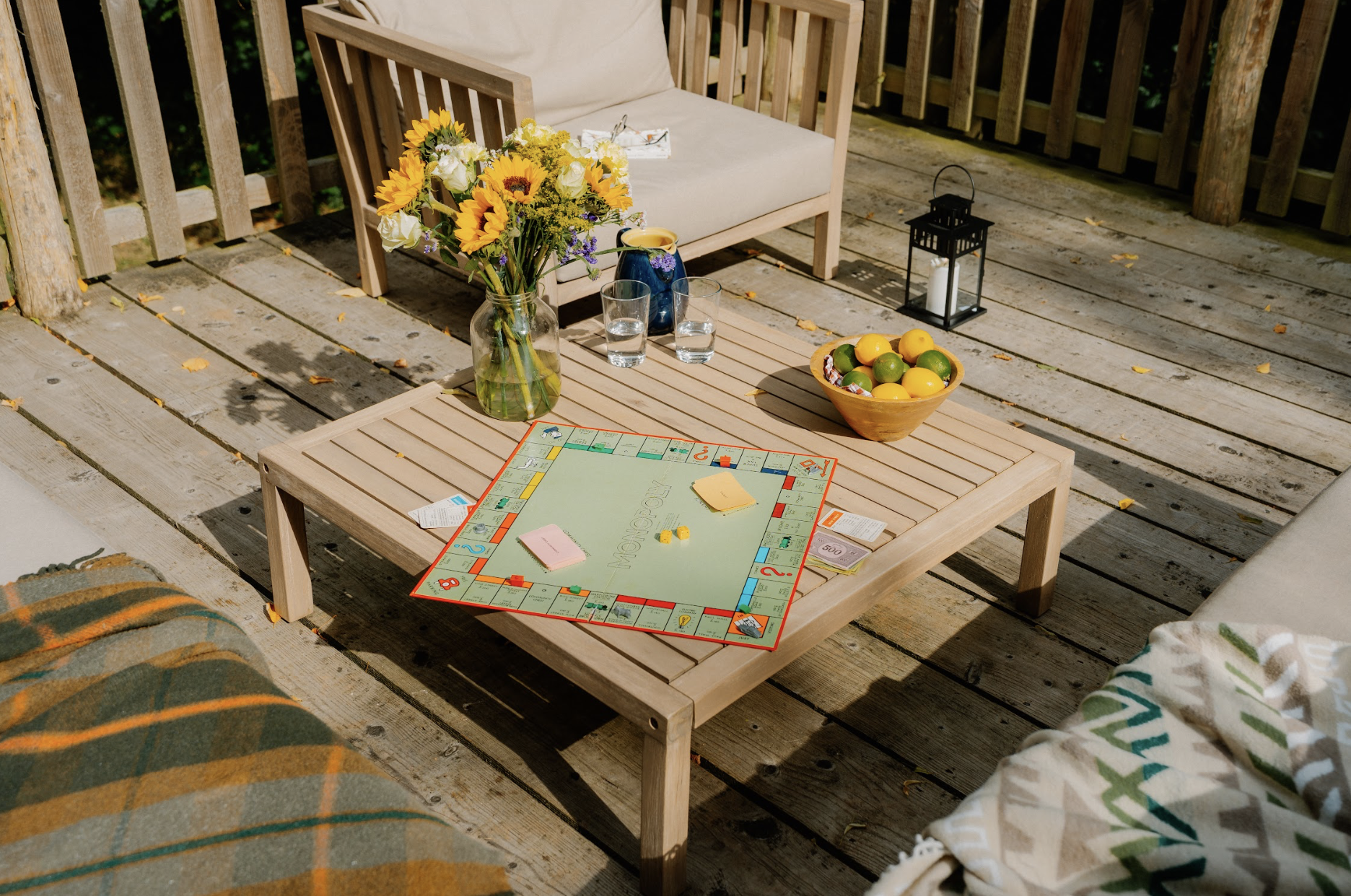 Board game, flowers and drinks arranged on the sunny private deck at Journeyman Treehouse