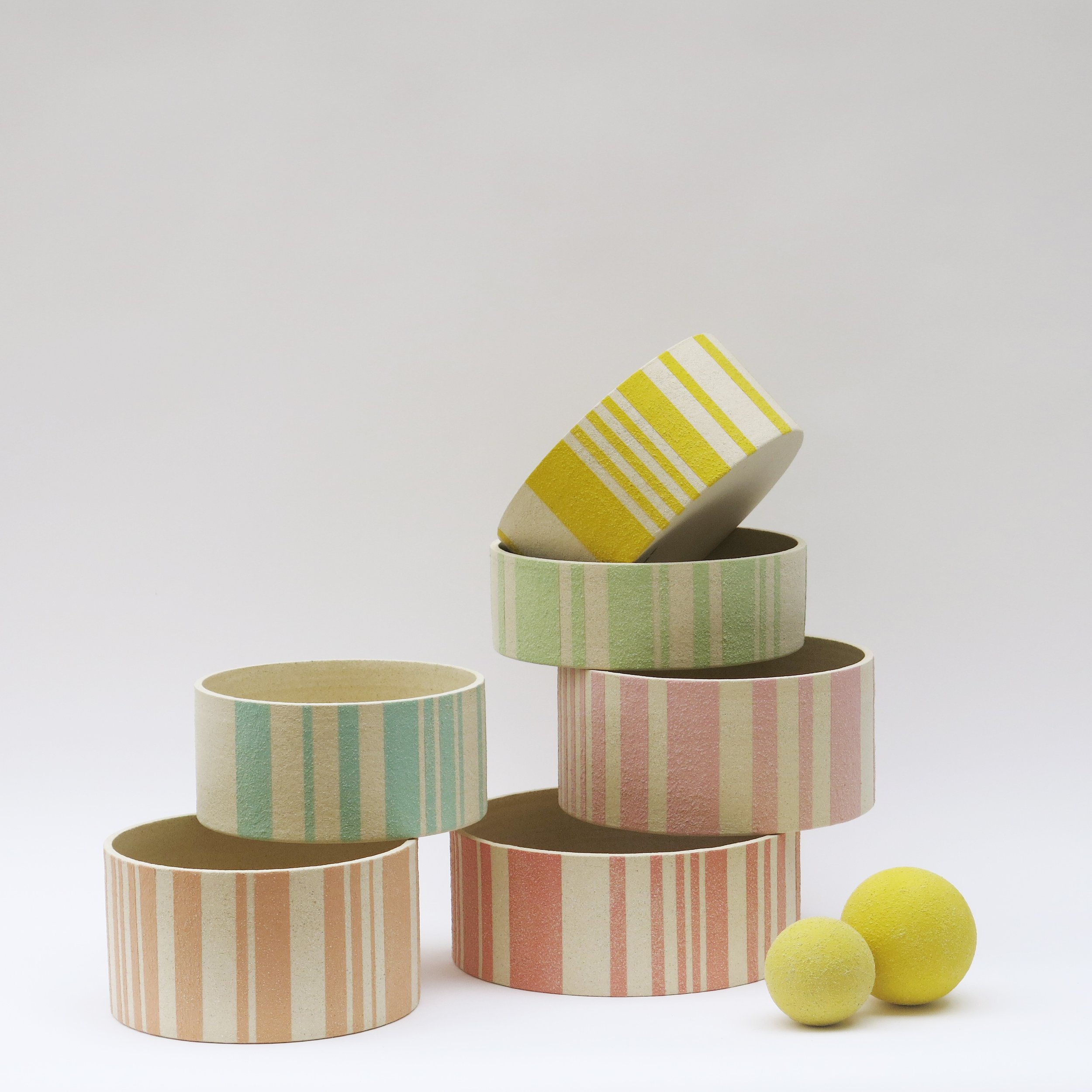 Détail d’une coupe Bandes en grès chamotté avec lignes colorées à l’engobe sur terre brute, présentée avec citrons, Julie-Zoé Michel.