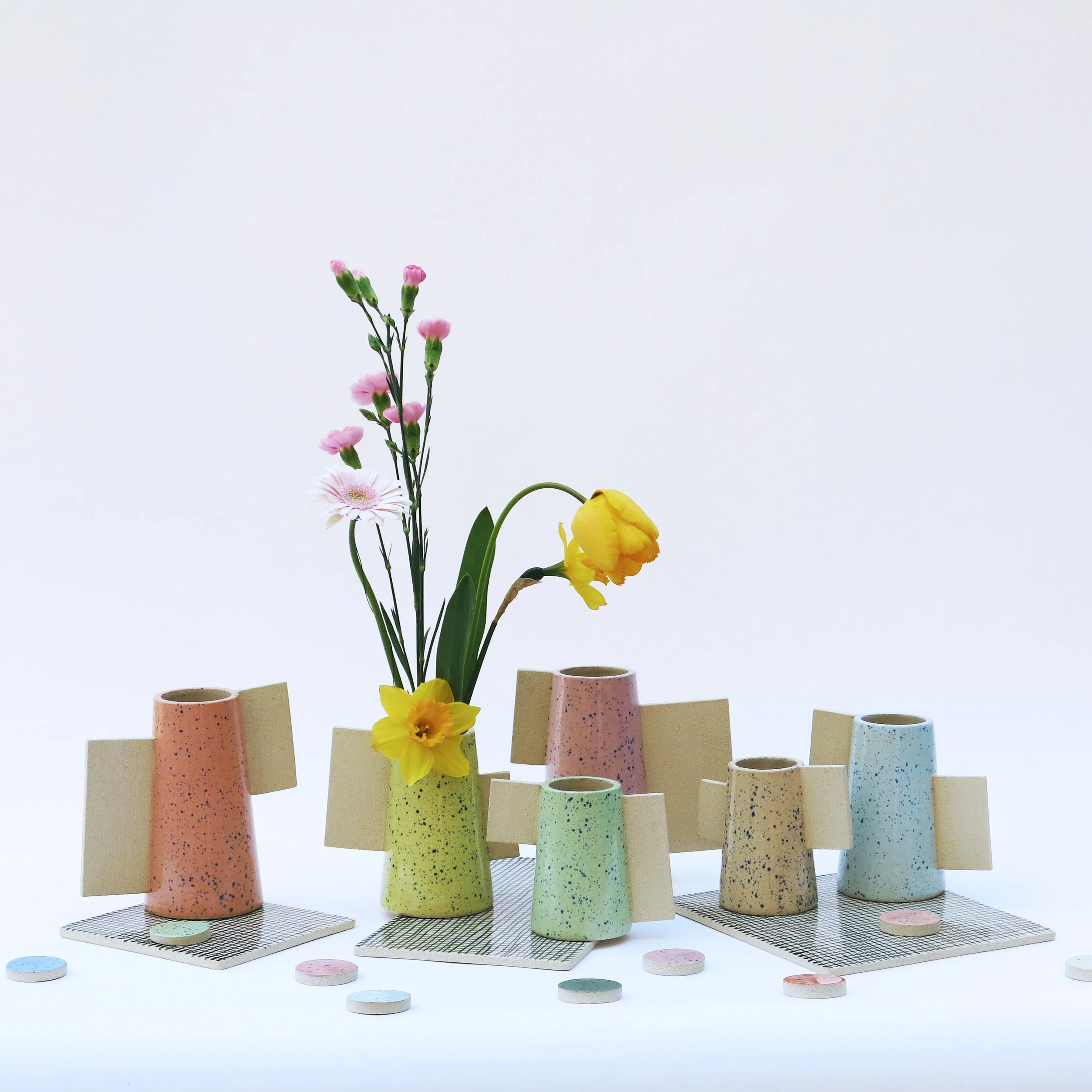 Ensemble de vases Les Machins en grès chamotté avec émail moucheté aux couleurs bonbon et éléments en terre brute, présentés avec fleurs, Julie-Zoé Michel – The Way of Dot.