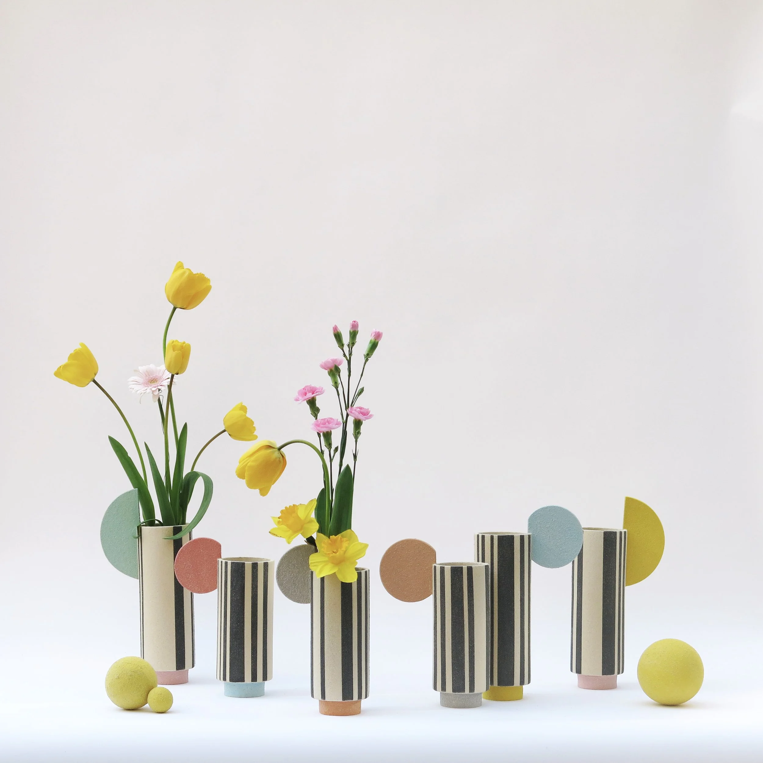 Composition de vases Colonnes en grès chamotté décorés à l’engobe, lignes noires et formes colorées, présentés en groupe, création Julie-Zoé Michel – The Way of Dot.