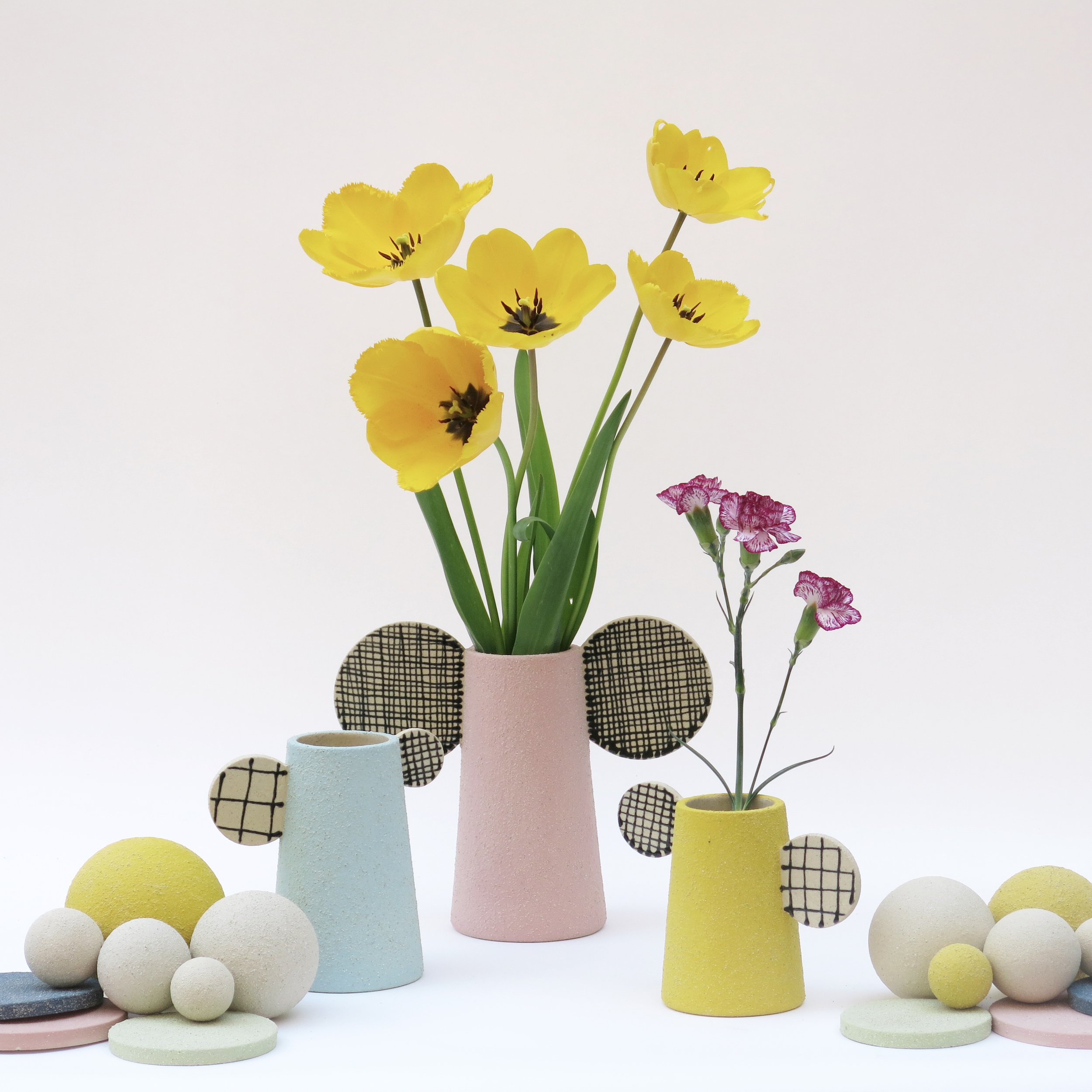 Vases Bidules en grès chamotté décorés à l’engobe coloré, avec éléments graphiques, composition avec fleurs jaunes, création Julie-Zoé Michel – The Way of Dot.