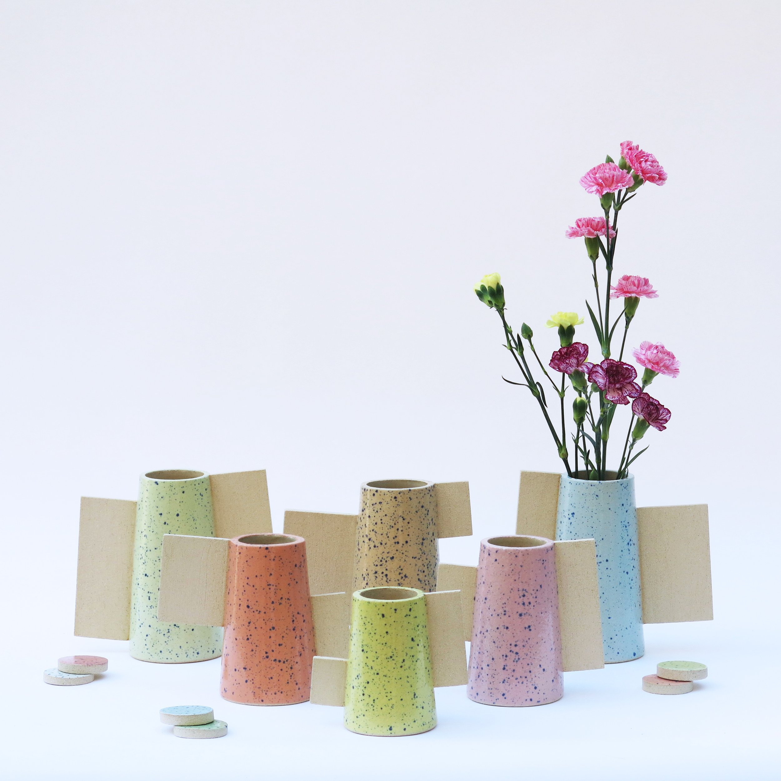 Vases Les Machins en grès, contraste entre émail moucheté et ajouts de terre brute, composition florale.