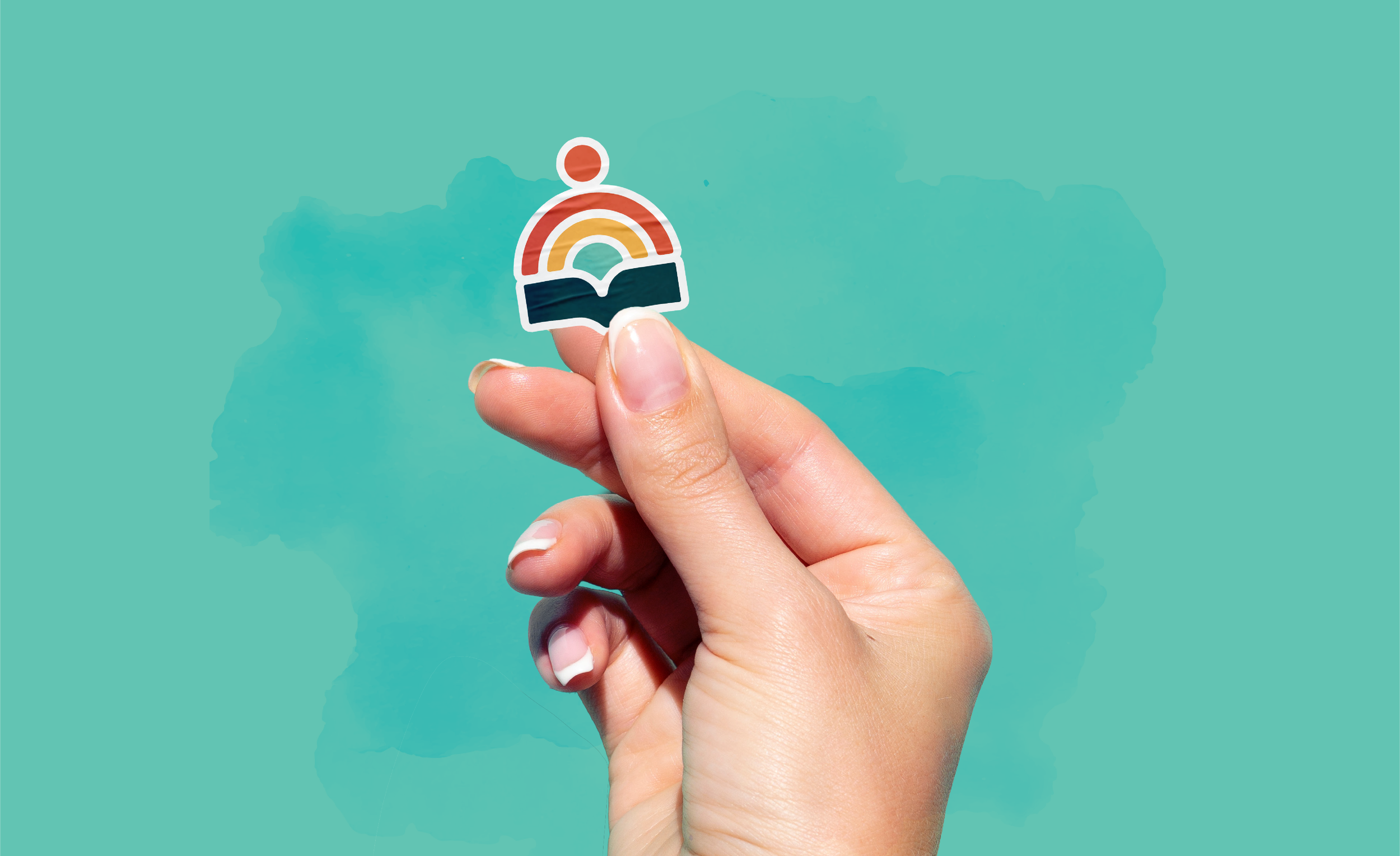 Hand holding a Puentes del Caribe icon logo sticker featuring yellow, orange-red, teal, dark teal, and cream colors, over a teal background with subtle watercolor texture.