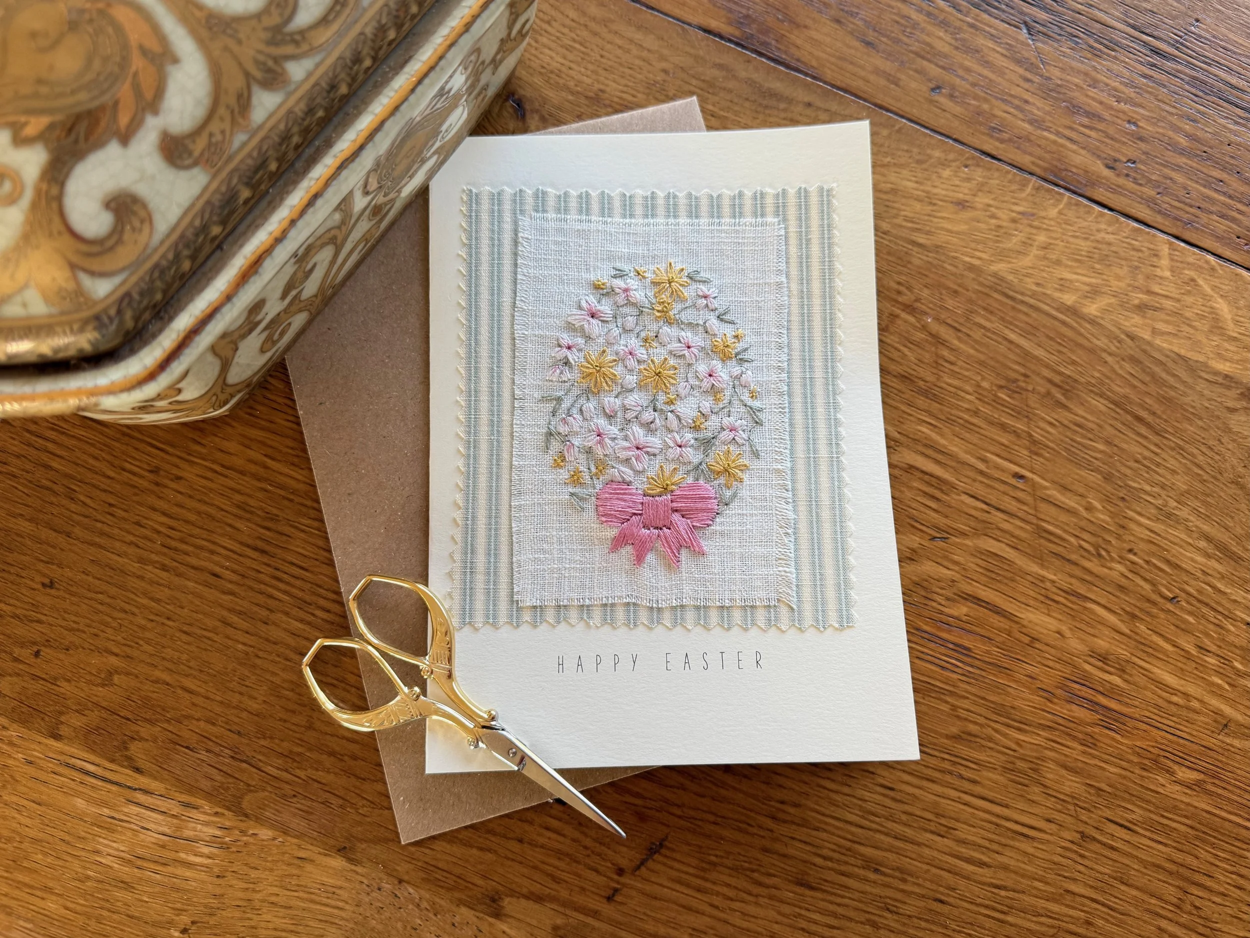 Easter greeting card featuring embroidered flowers with a pink bow.