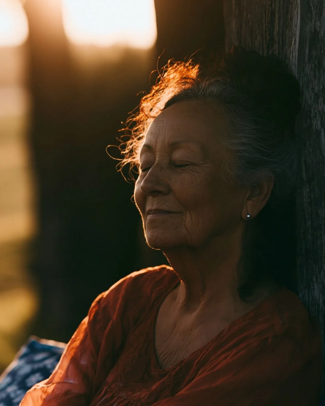 A woman leans back with the sunlight on her face.
