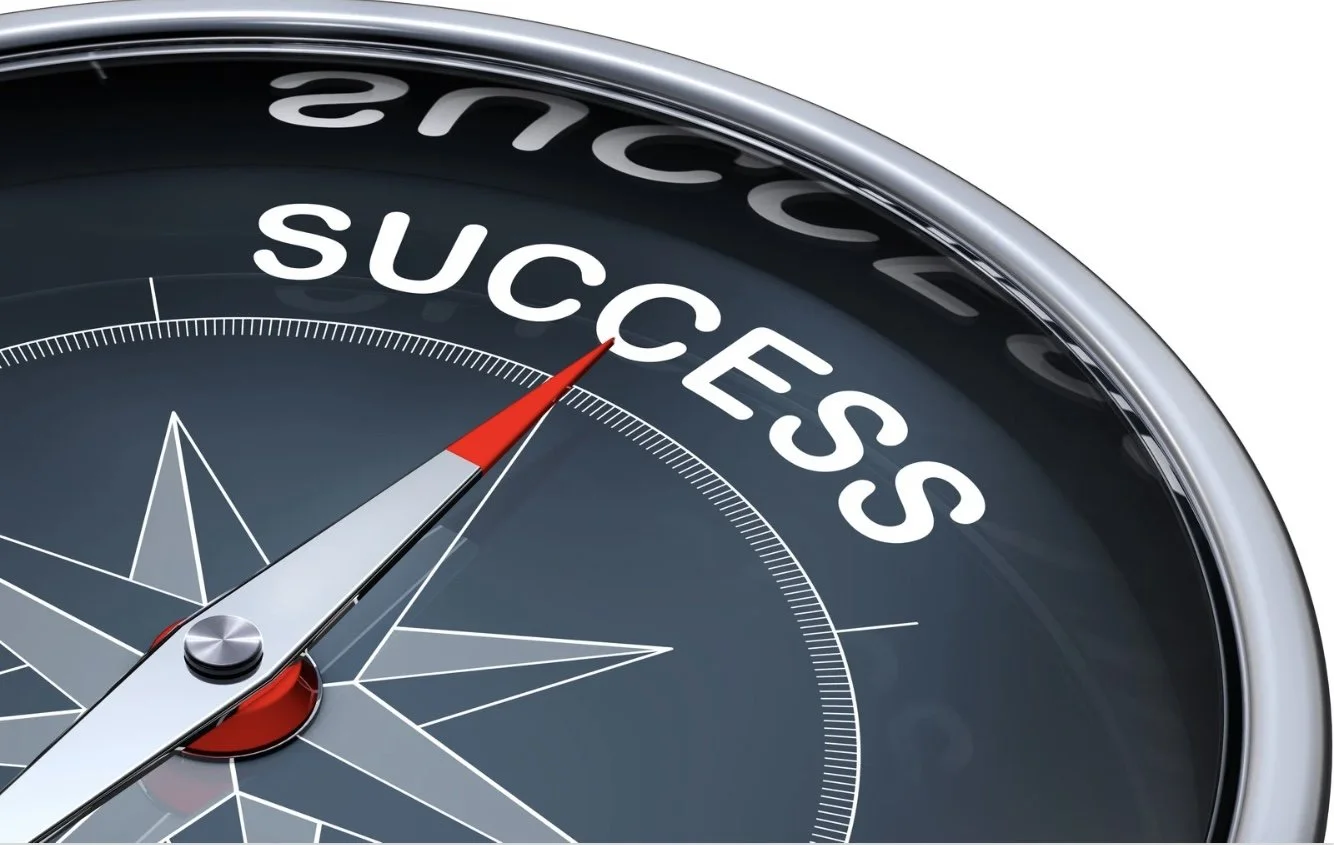 A compass with the needle pointing to the word 'SUCCESS' in small business.