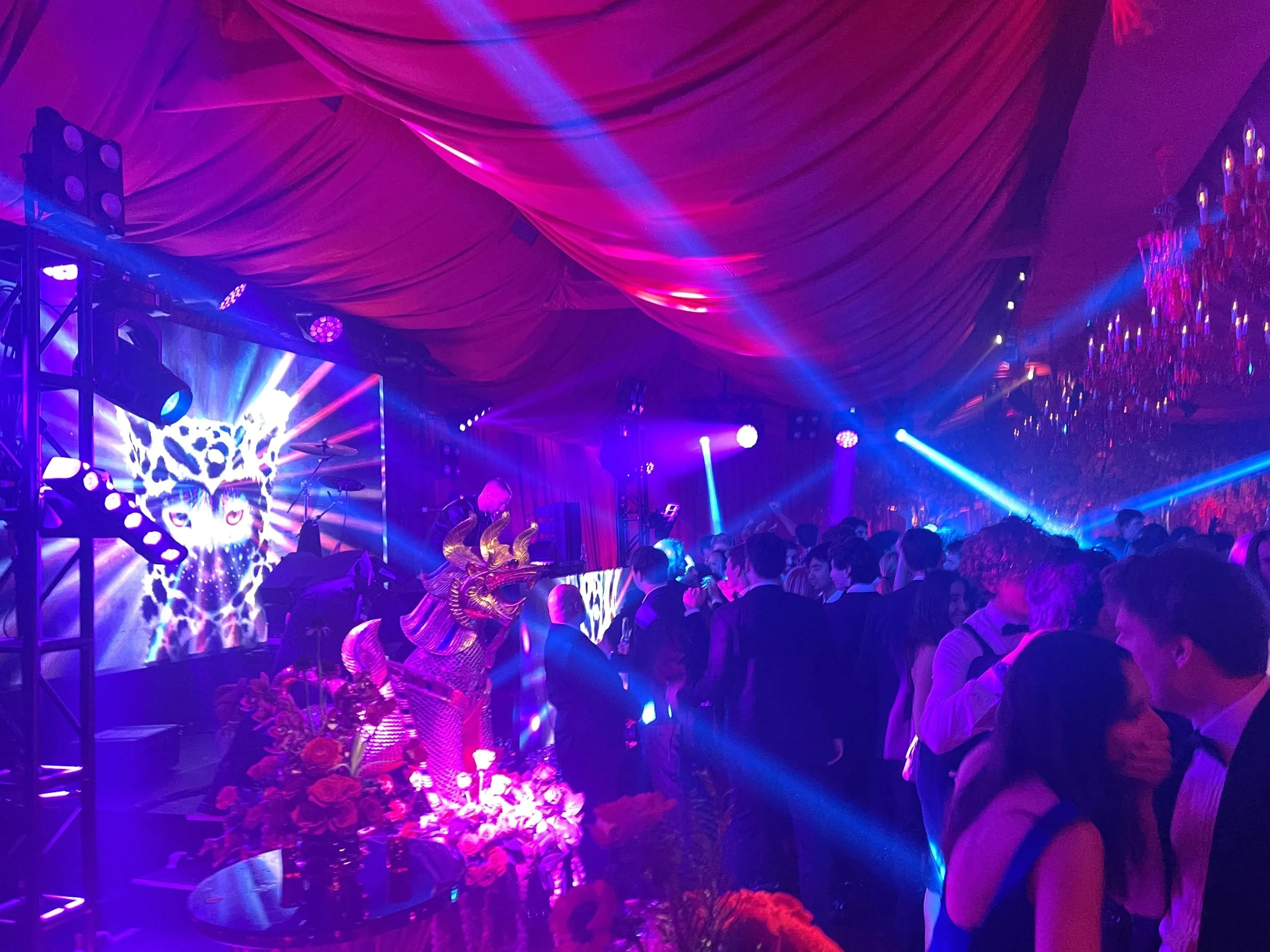 Intelligent lighting effects at tented wedding reception with DJ and custom ceiling drape