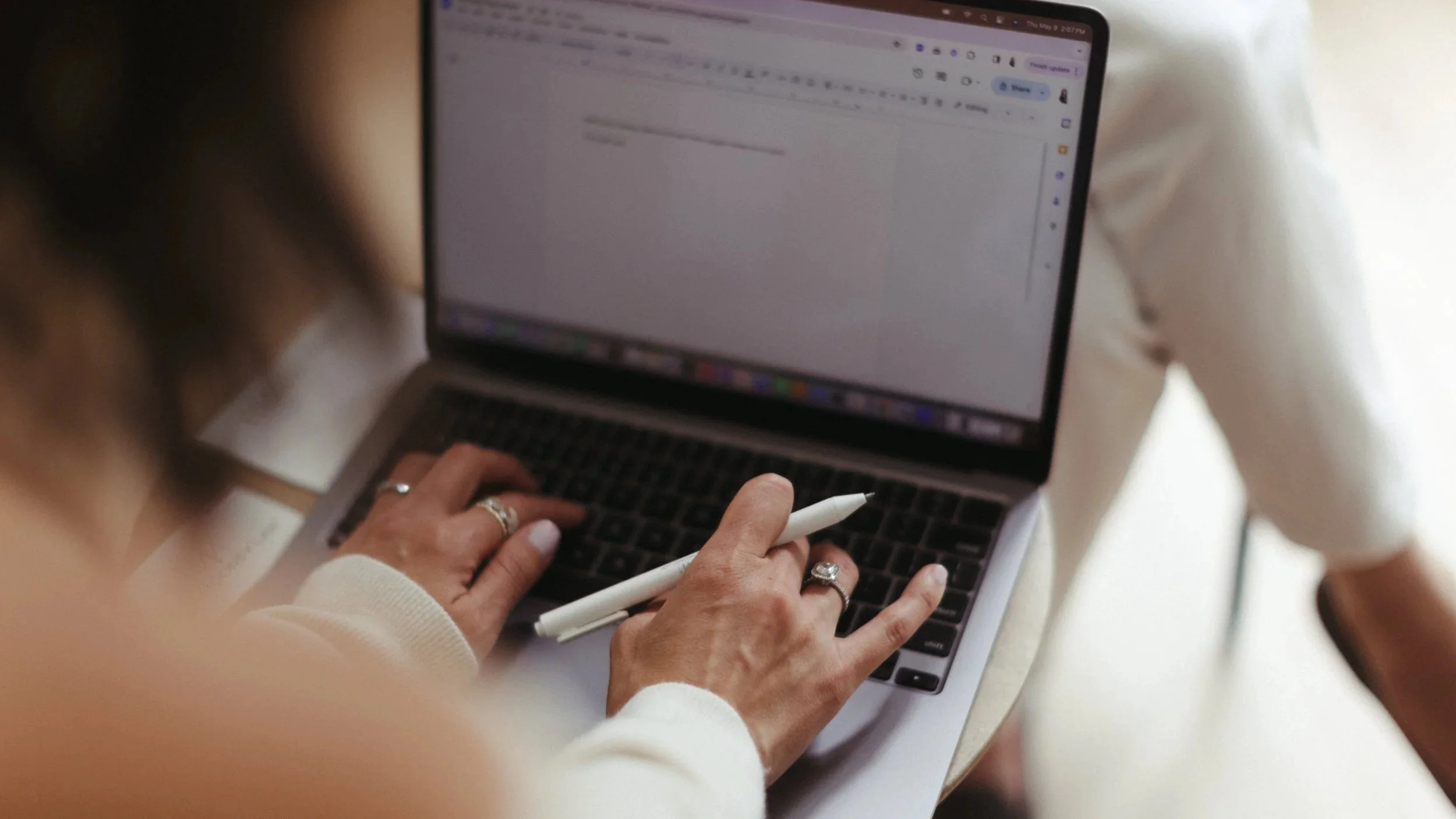Two people reviewing a document on a laptop while discussing trademark strategy for rebranding a business
