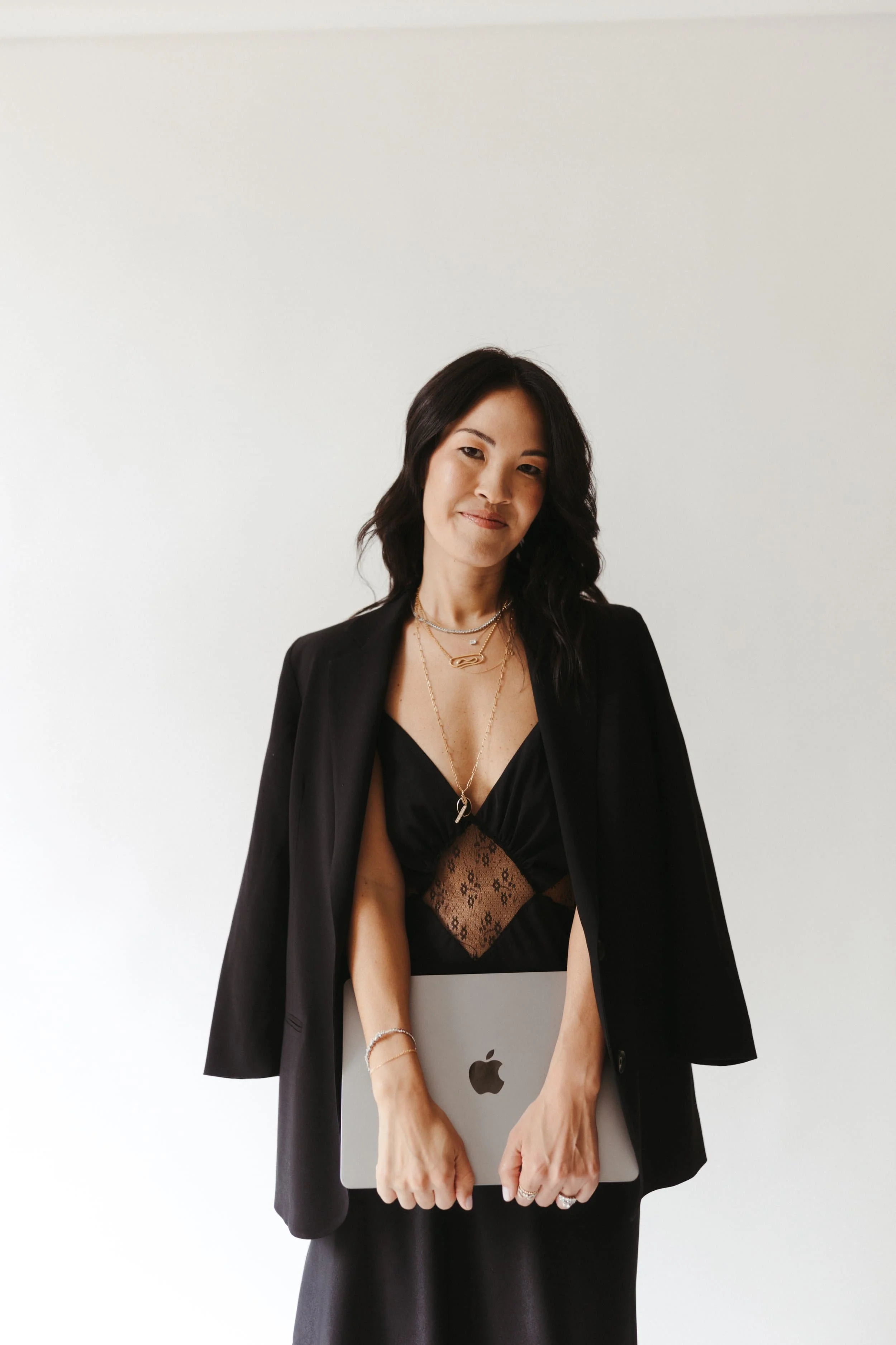 Mika Mooney, business and trademark attorney, holding a laptop during a professional brand portrait session.