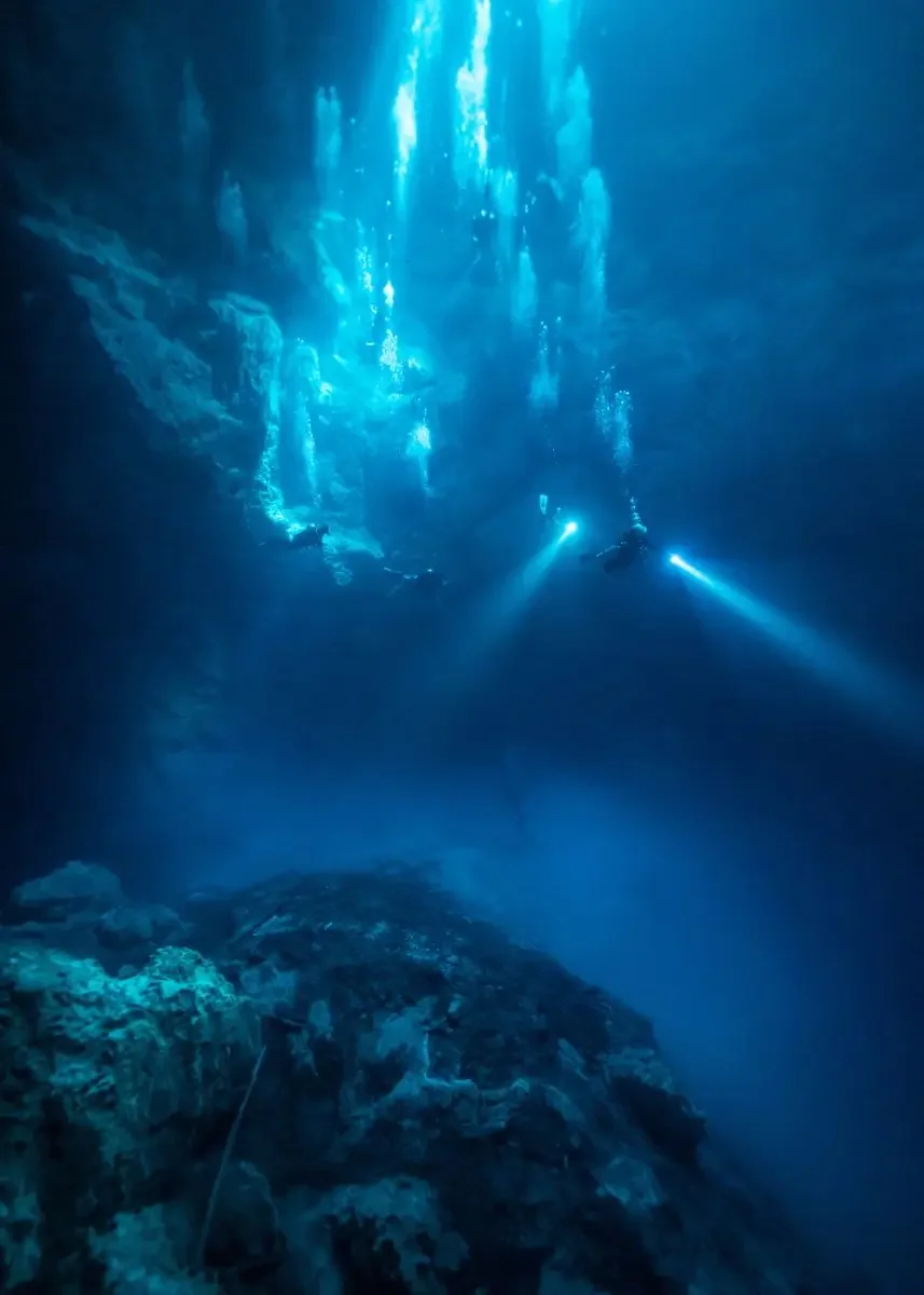Divers descend into The Pit Cenote in Yacatan Mexico