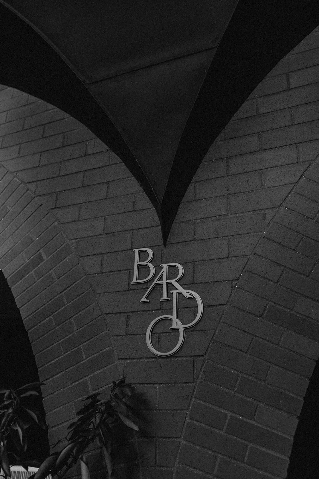 Black brick wall with a sign that says 'BAR' in stylized metallic letters.
