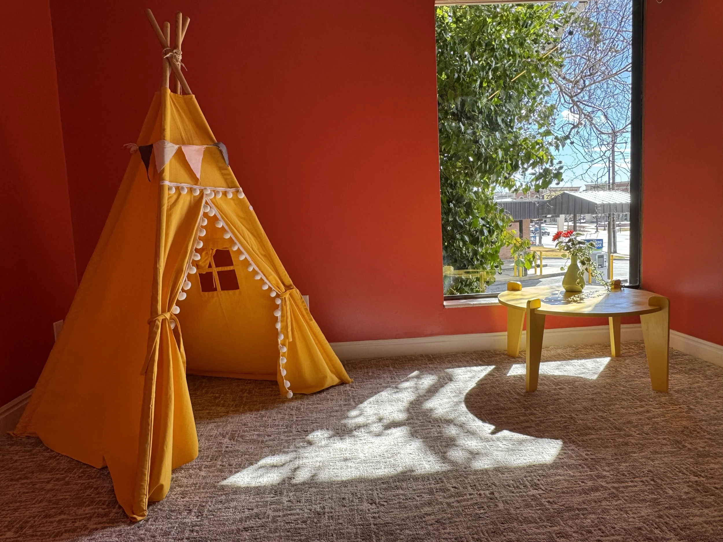 yellow play tent in red room with bright sunlight shining through the window