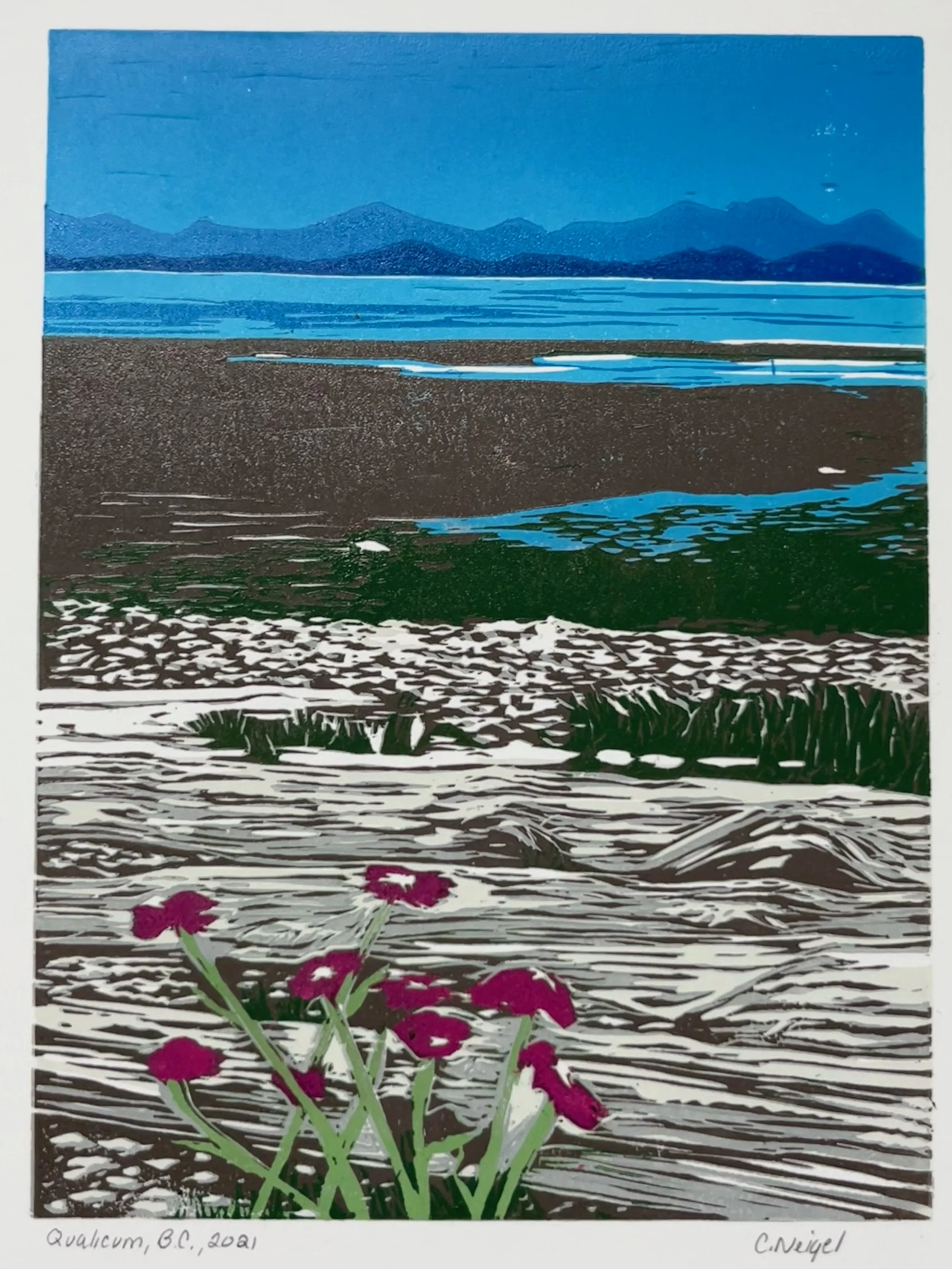 logs and flowers in foreground of a view towards water