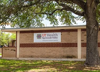 UT Health Rio Grande Valley building exterior with tree and sign.