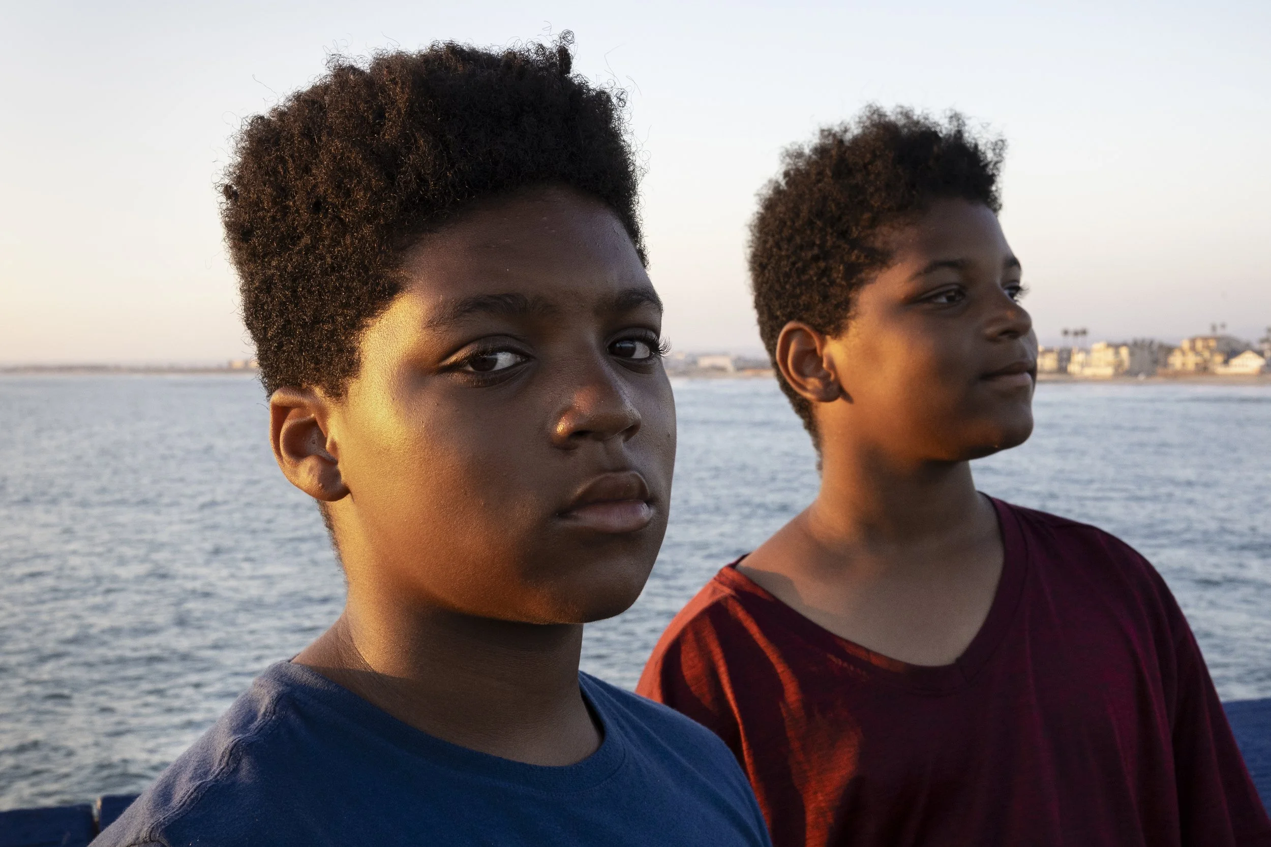 Jassayah Dart, 11, and his twin brother Massayah Dart, 11, stand on the Imperial Beach Pier July 7, 2025, at sunset in Imperial Beach, Calif. Being local residents, they are unable to enjoy the beach to its fullest extent because of its continued clo