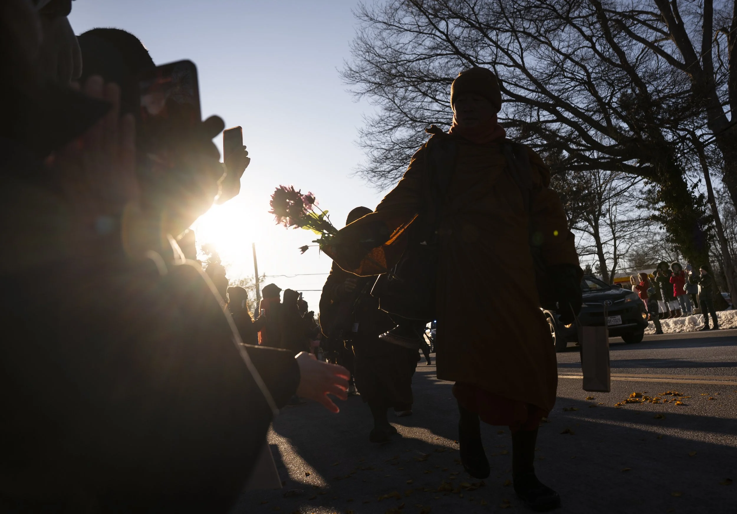 The venerable Bhikkhu Pannakara leads the Theravada Buddhist monks Feb. 8, 2026, during the Walk For Peace and hands out flowers to the crowd in Alexandria, Va. The monks are walking 2,300 miles from  Fort Worth, Texas, and will be arriving at the U.