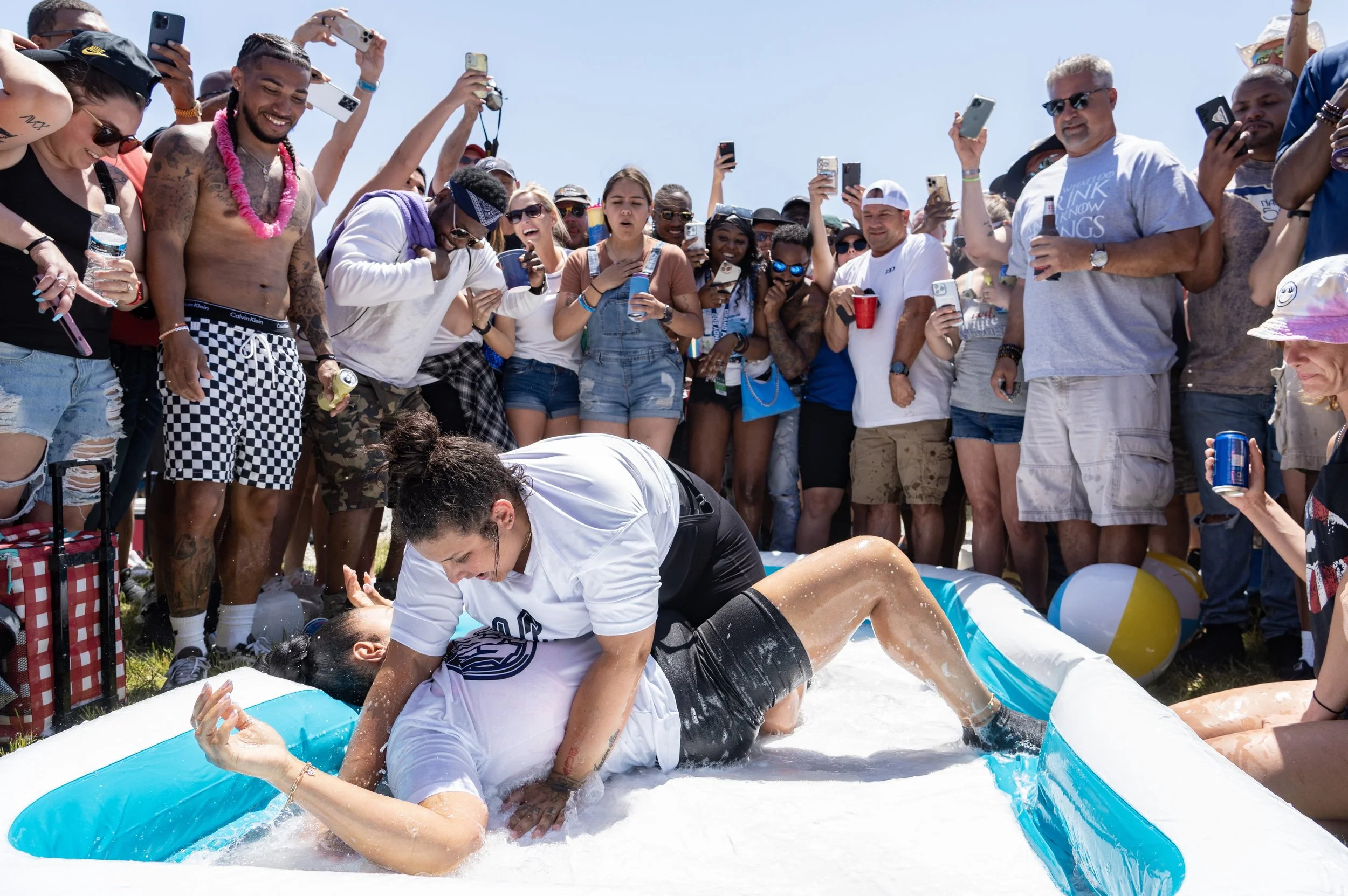 Two fans wrestle in a pool as others cheer May 26, 2023, during Carb Day ahead of the 107th running of the Indianapolis 500 at the Indianapolis Motor Speedway in Indianapolis, Ind.
