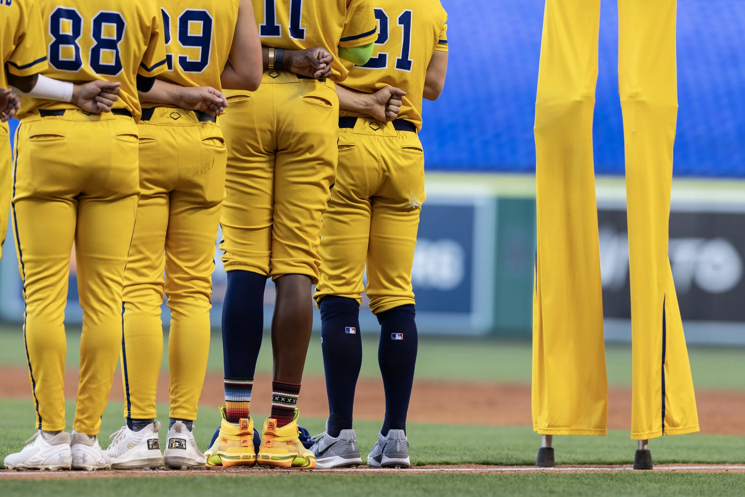 The Savannah Bananas line up during the national anthem before taking on the Firefighters at Angel Stadium May 30, 2025, in Anaheim, Calif. Bananas' star Dakota "Stilts" Albritton towers above his teammates doing what he describes as the hardest task