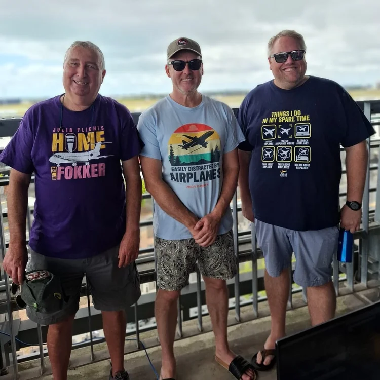 Three fans wearing Julia Flights tees at the airport