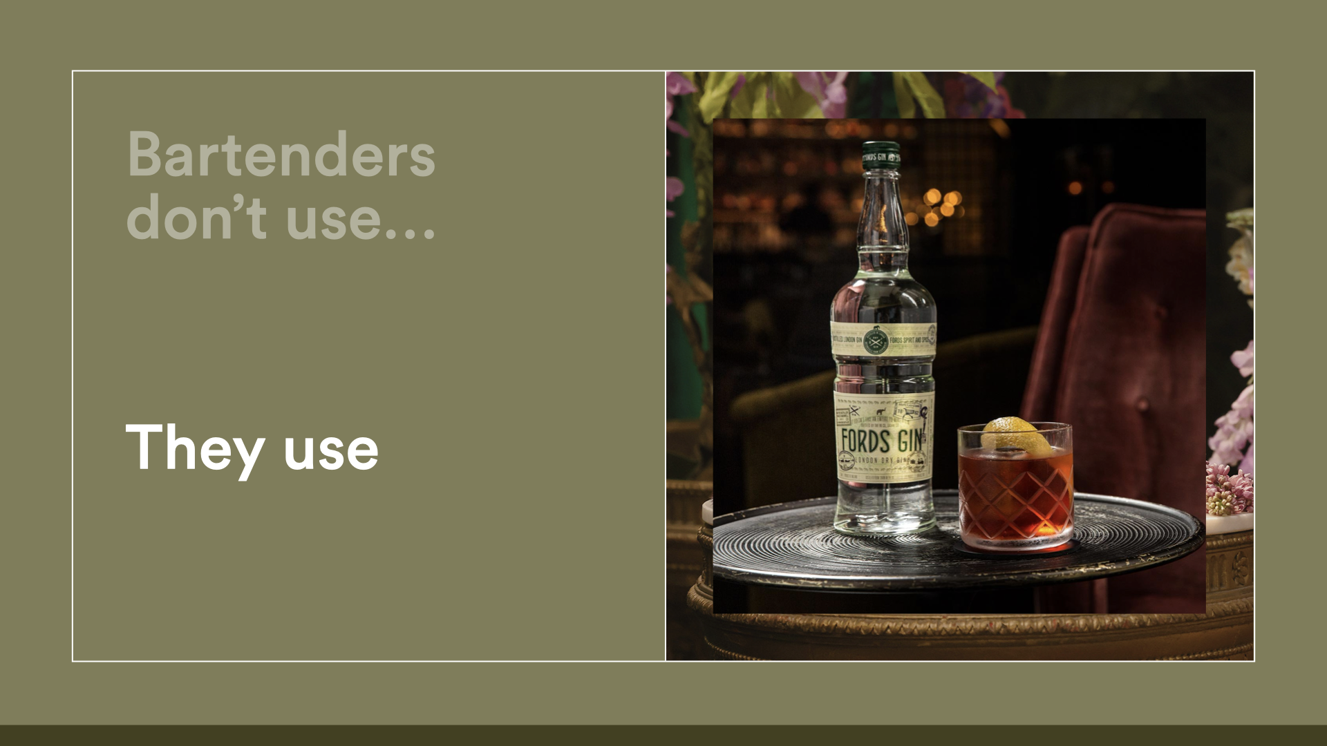 A bar setting with a bottle of Fords Gin and a glass of a cocktail with lemon on a silver tray.