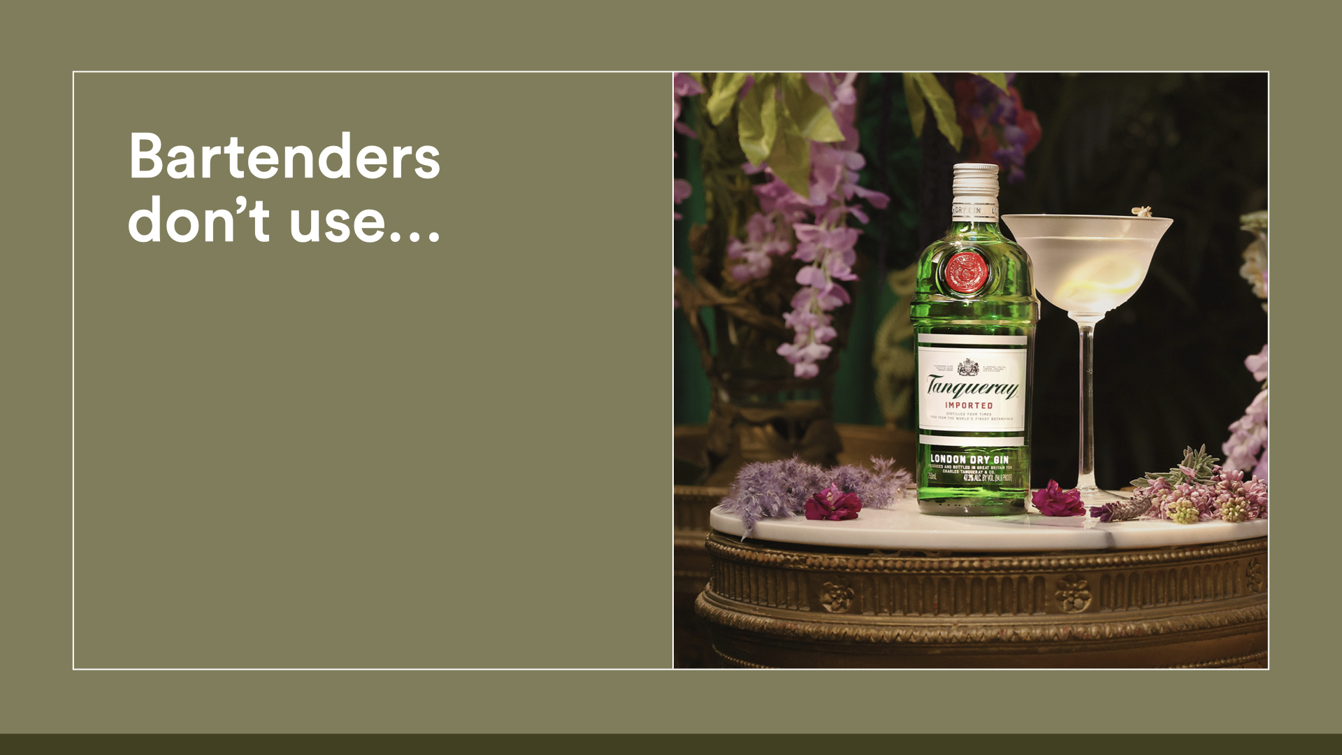 A cocktail glass and a bottle of Tanqueray London Dry Gin on a decorative table surrounded by pink and purple flowers.