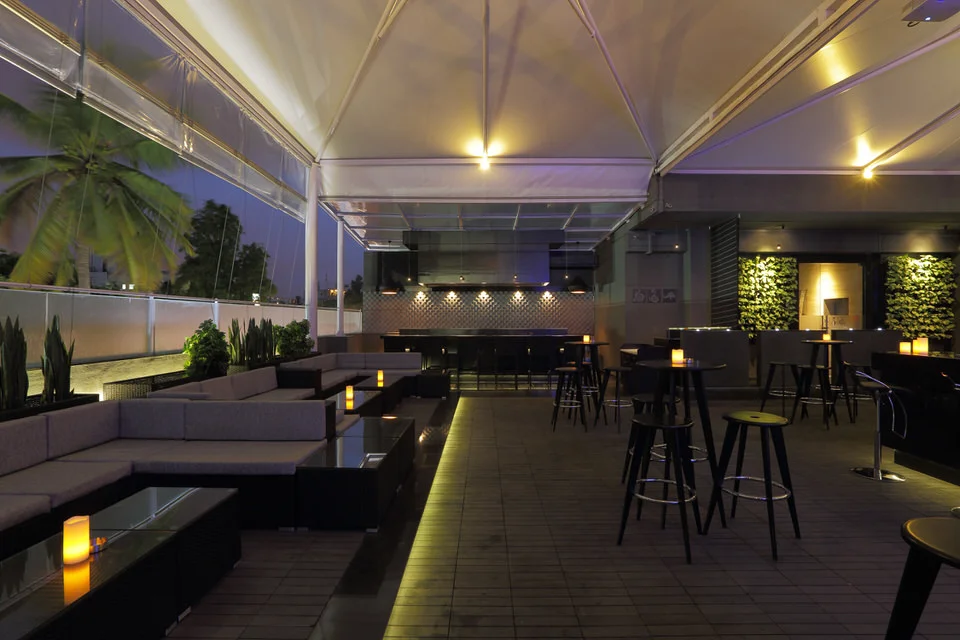   Troika is a spacious bar with a great view, exactly the kind of uncrowded place to hang out in peace. It has a variety of seating arrangements centered around an island bar and is open on all sides, making it a picturesque sight in the evenings. Wo