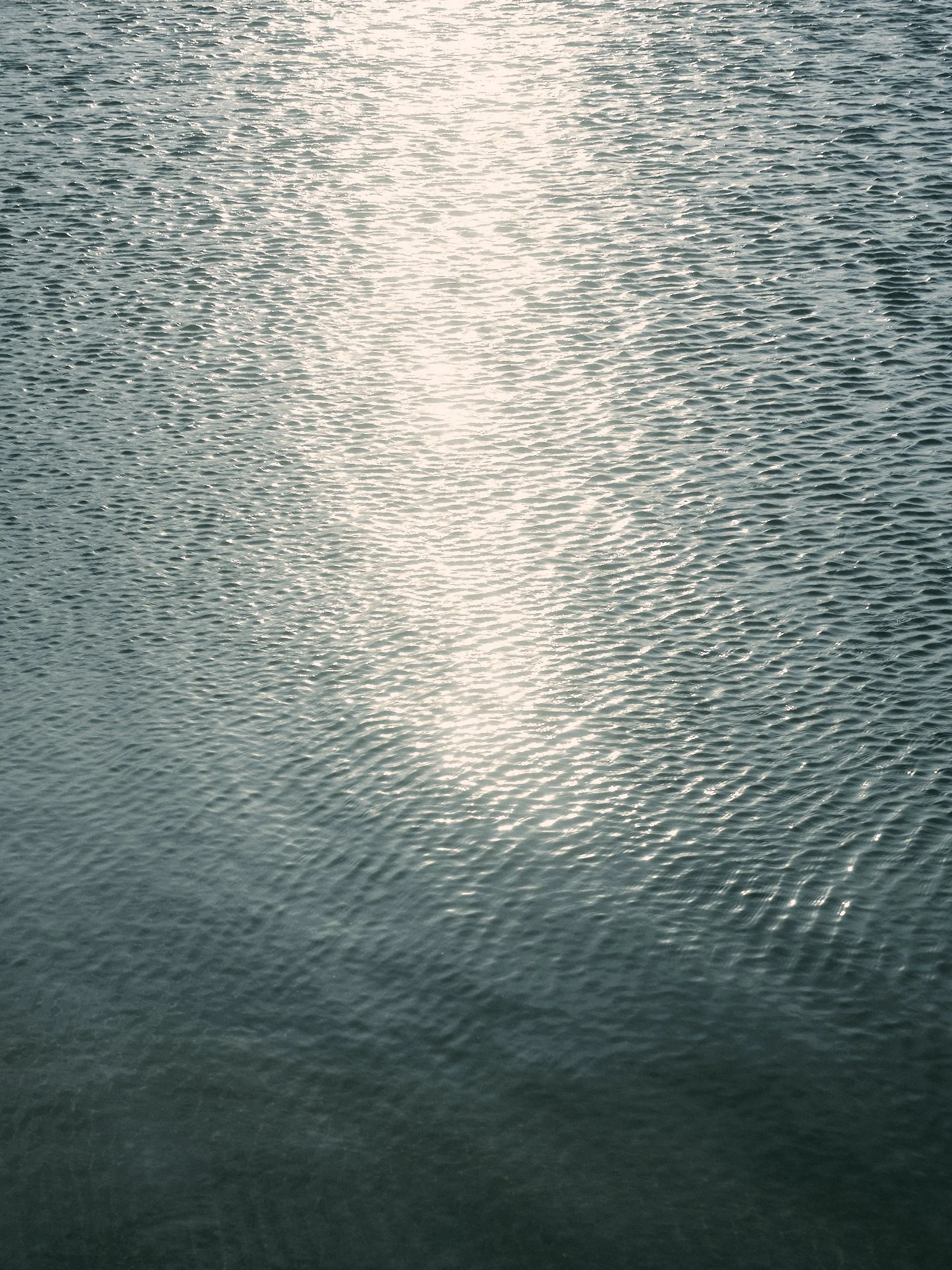 Reflejo del sol en el agua, creando un efecto brillante en la superficie ondulada.