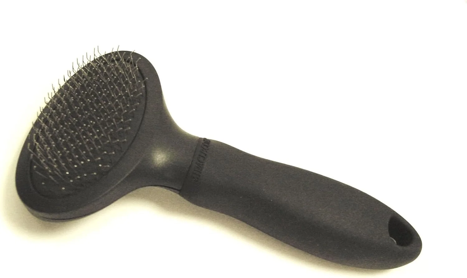 Black slicker brush with an ergonomic handle and fine, angled metal bristles, designed for grooming and removing loose fur from dogs and cats