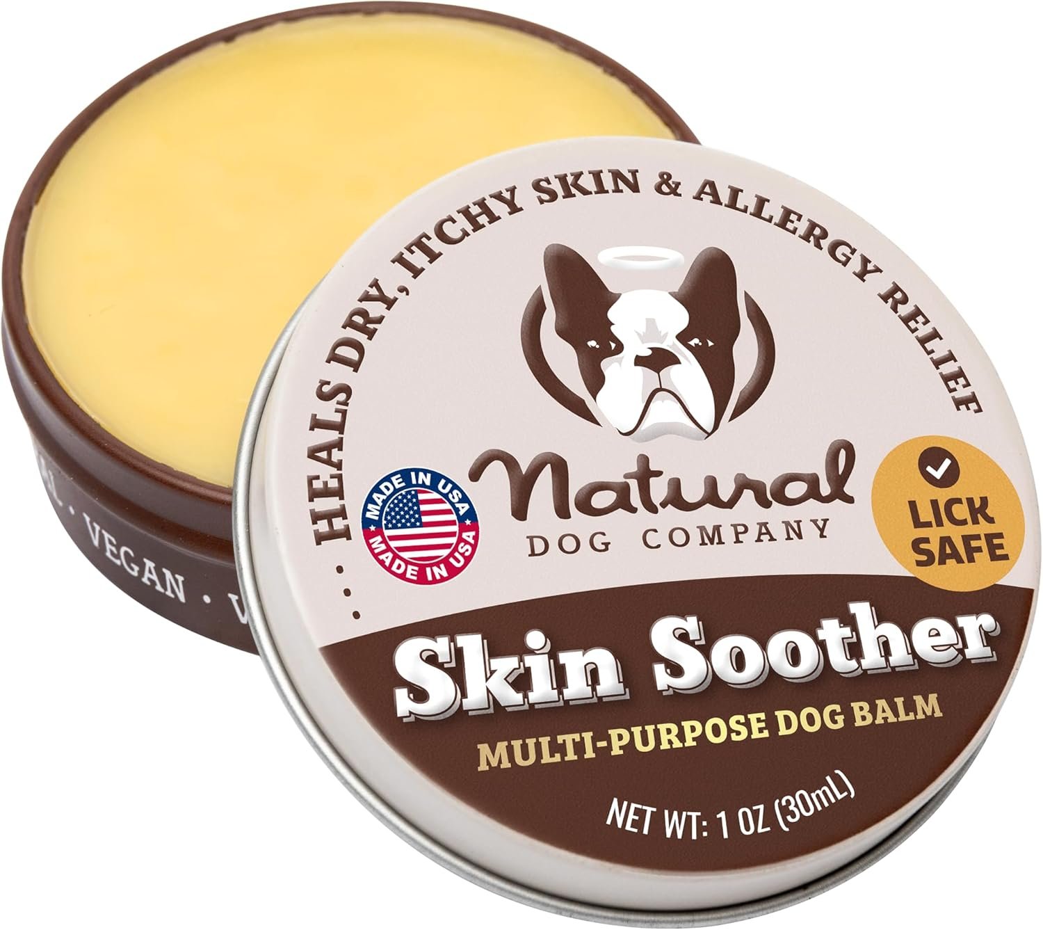 Open tin of Natural Dog Company Skin Soother multi-purpose dog balm showing yellow balm inside and labeled lid with a dog face illustration, labeled as lick-safe and made in the USA.