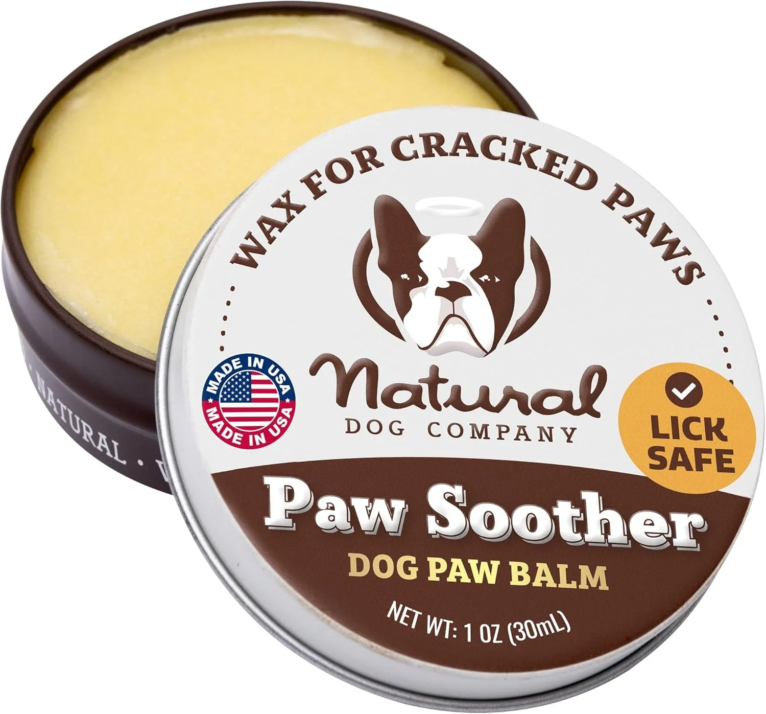 Open metal tin container of Natural Dog Company Paw Soother Dog Paw Balm, featuring a Boston Bulldog illustration and label indicating it is made in the USA, lick safe, and 1 ounce size.
