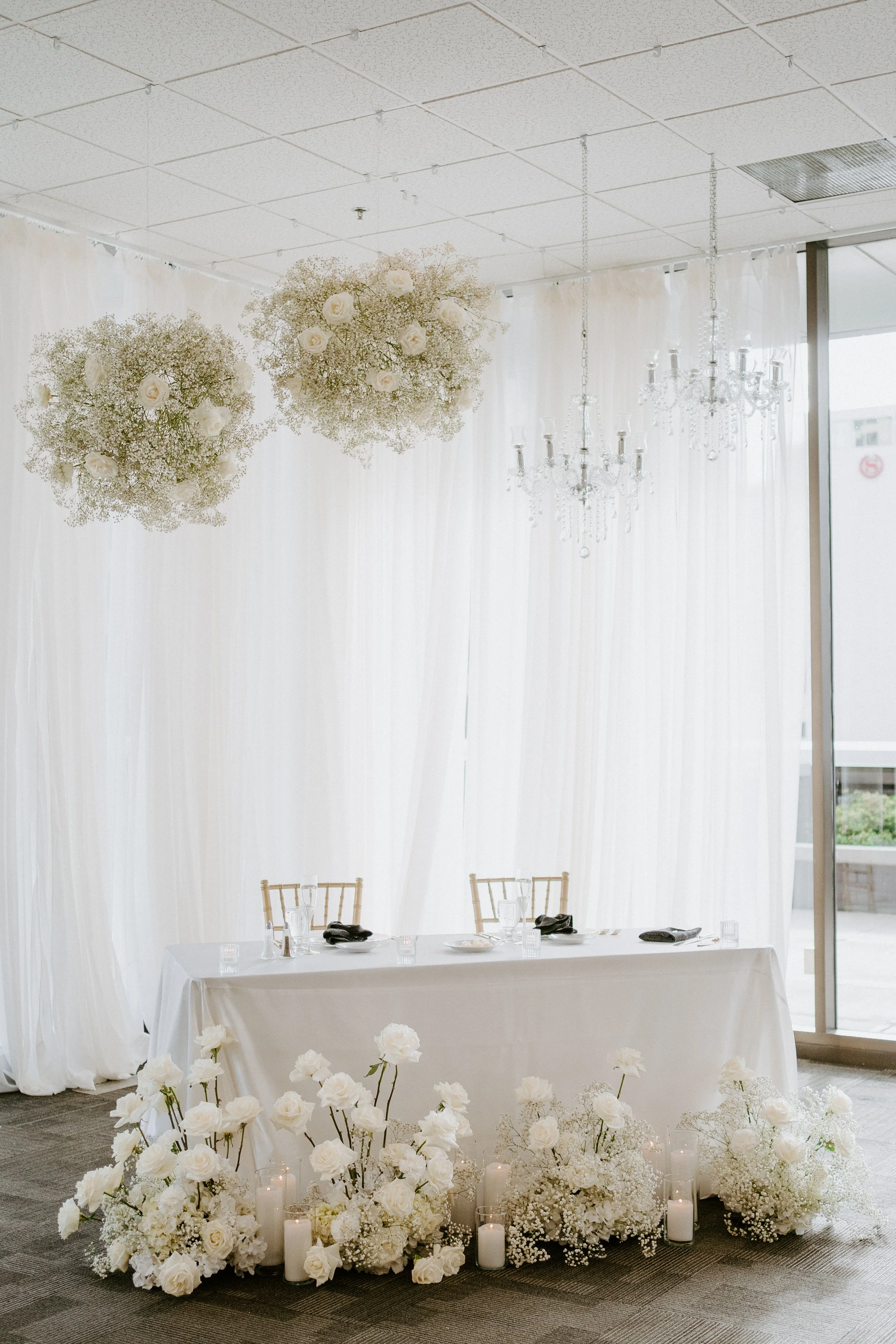Elegant ground floral arrangements placed along a wedding head table by K.I.S Florals in Indianapolis for a romantic reception design.