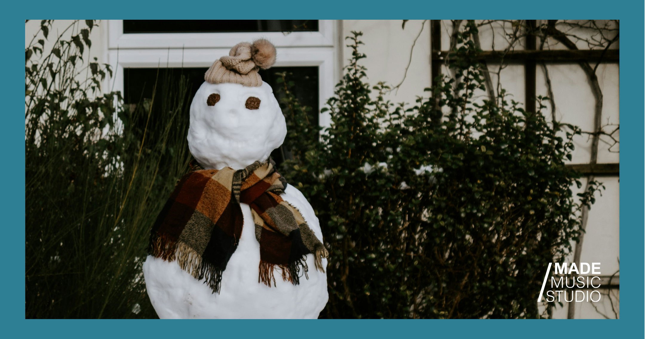 A snowman wearing a hat and scarf stands against a snowy background.