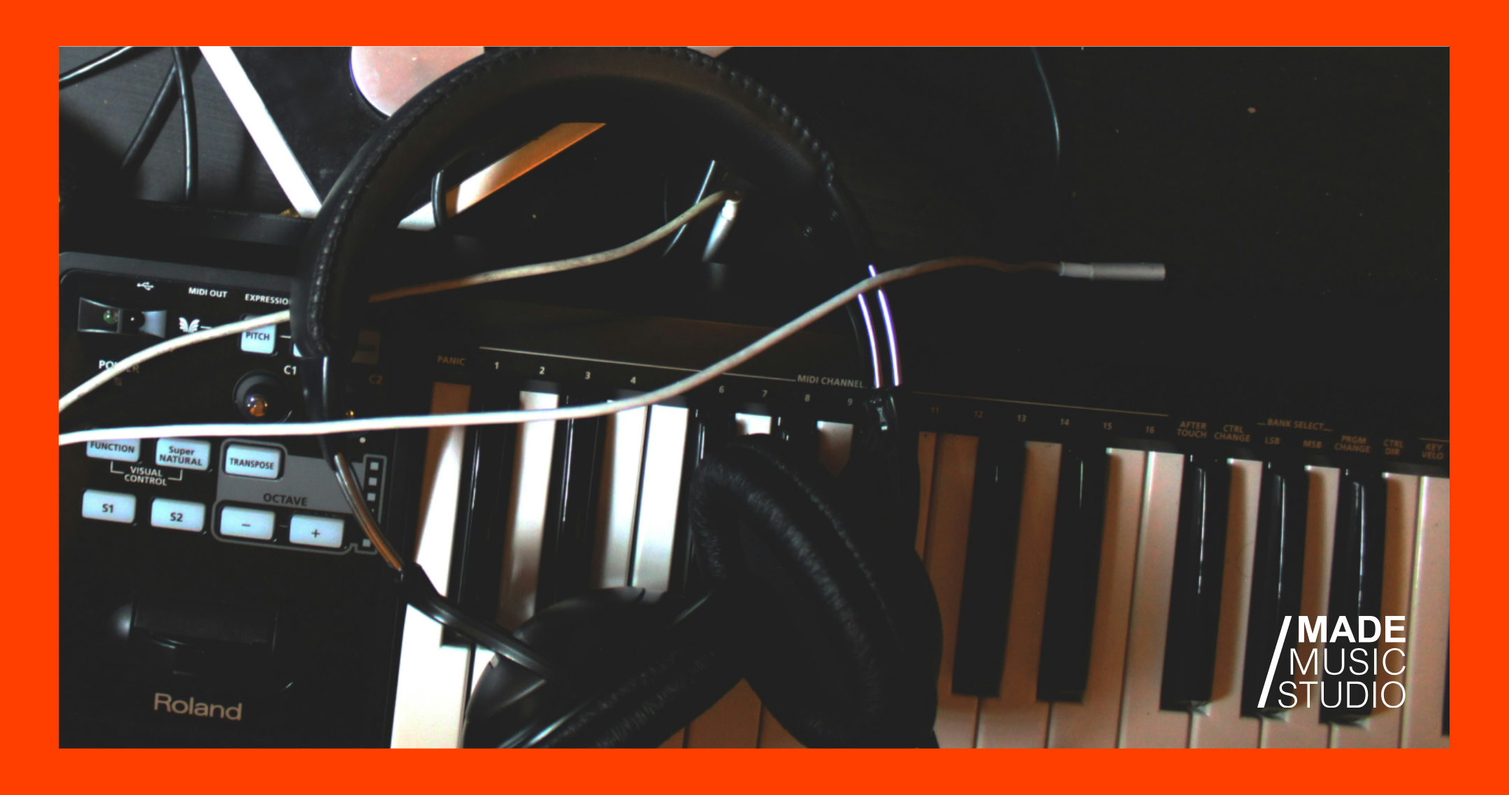 A keyboard with headphones and a microphone nearby, indicating a workspace for audio recording or gaming.