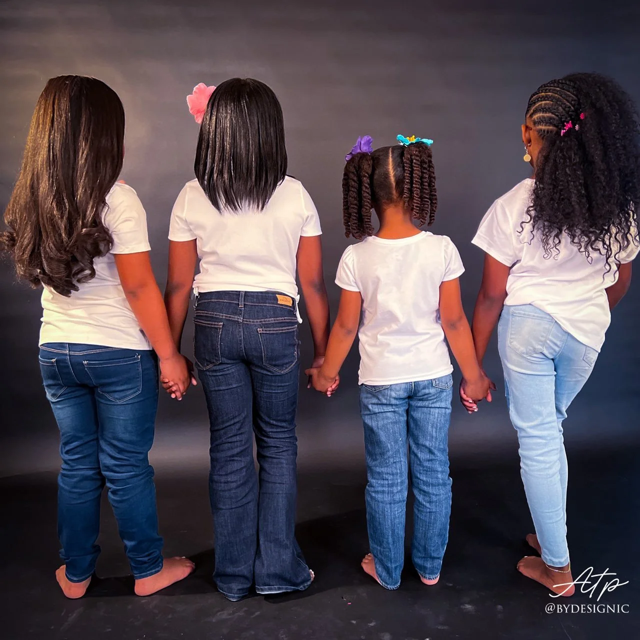 Four young clients displaying their hairstyles from behind