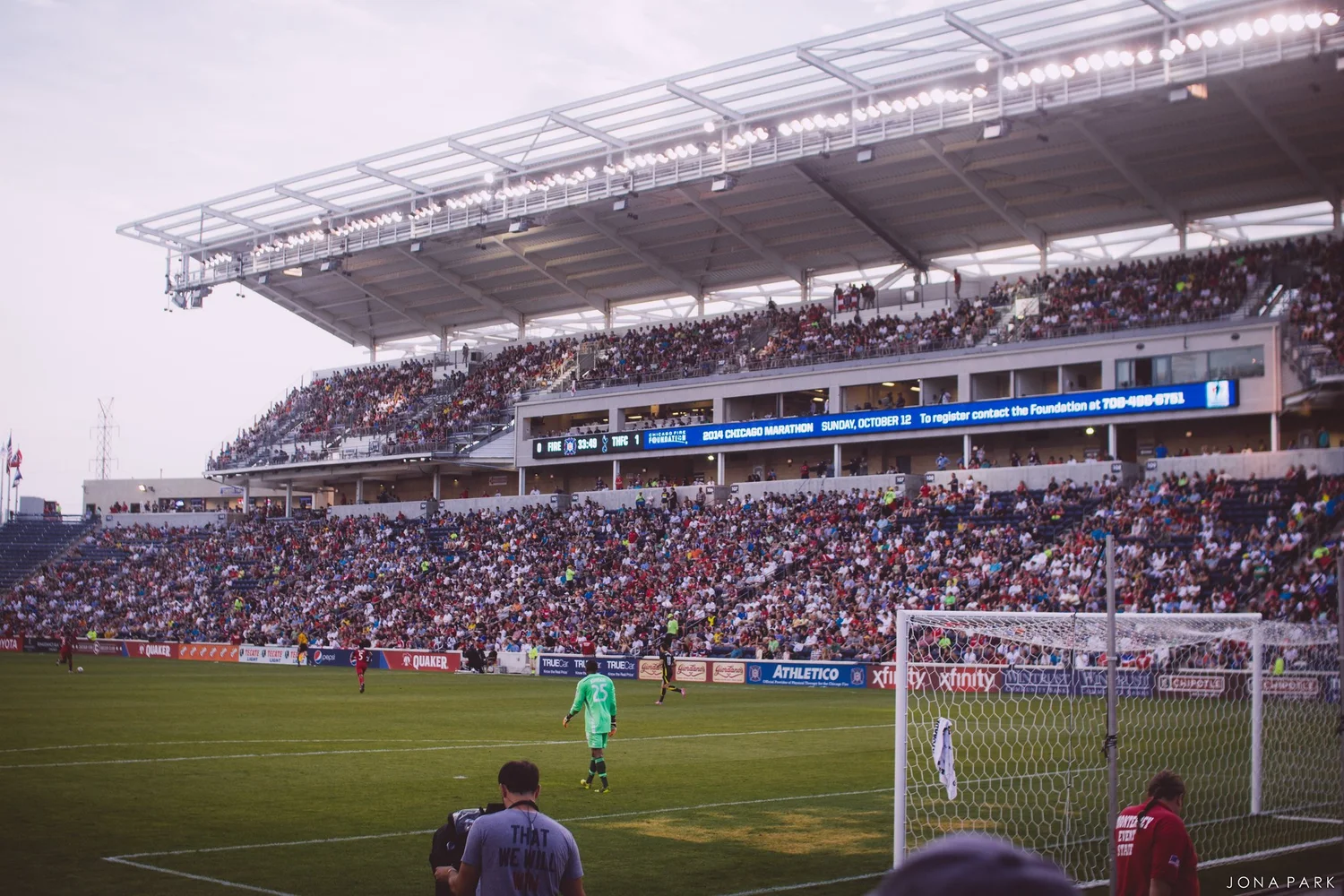 Crowded stands and a lit roof over a soccer pitch at the Bridgeview stadium during a Chicago Fire match